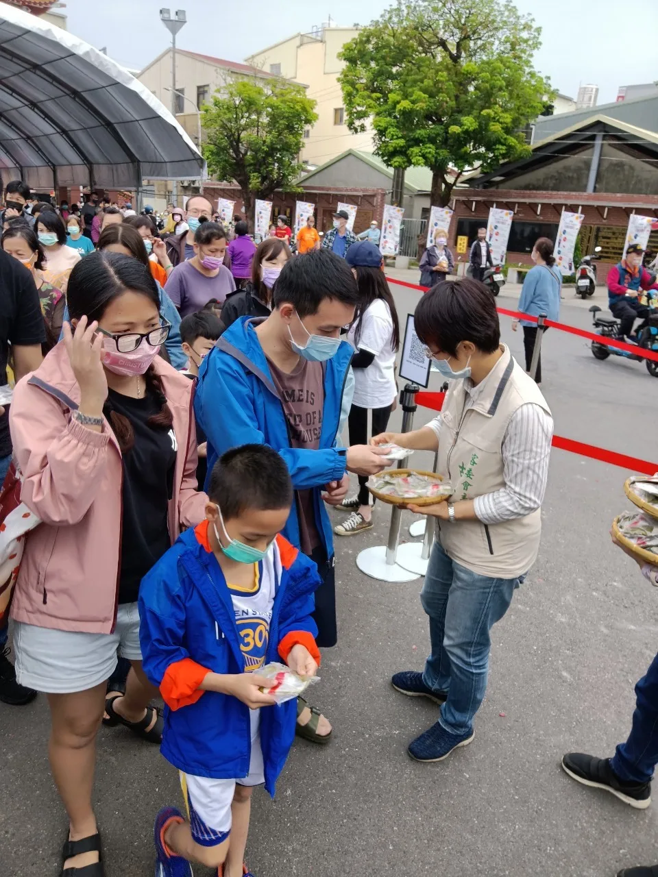 台南市政府客家事務委員會主委古秀妃(右一)分送糖果給參加伯公生慶典的民眾。台南市政府客家事務委員會提供