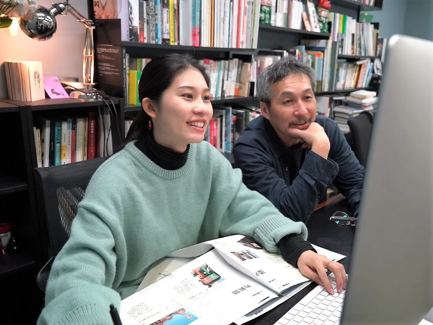 《靛花》總編輯李取中(右)與排版設計師余宥棋(左)調整刊物版面。范修語攝