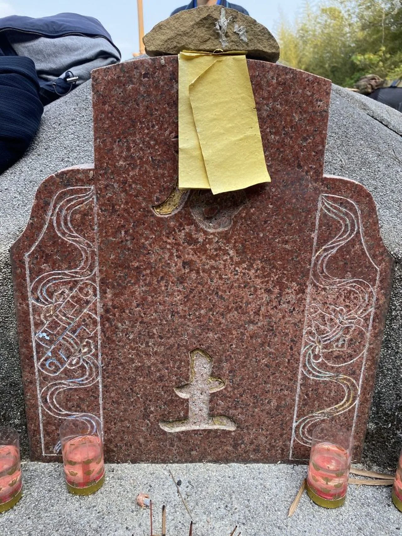 客家人掃墓會準備黃嘏紙（黃色墓紙）壓在墓碑墳頭，有趨吉避凶之意。江夏源攝。