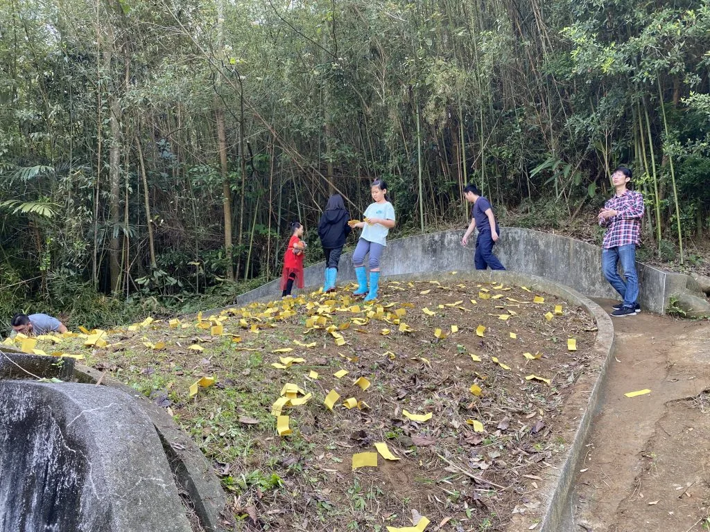 除了在墳頭押上黃嘏紙，墳墓泥土處也會用小石頭壓上黃嘏紙，有趨吉避凶之意。江夏源攝。