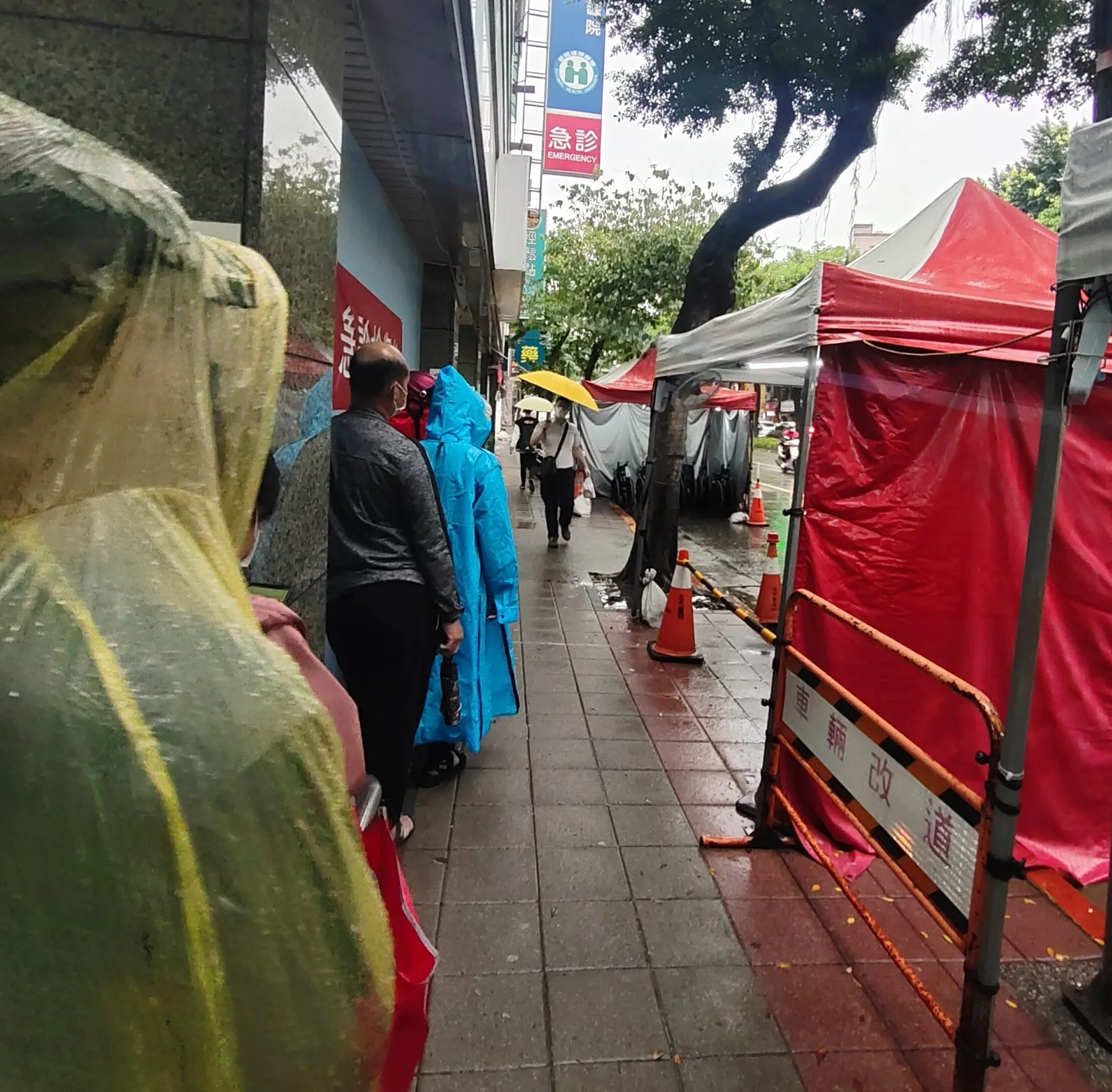 5月11日一早7點不到，沿著西園醫院騎樓，是滿滿的冒雨排隊人龍，每個人手上都拿著快篩陽性的試劑，等待掛號PCR。