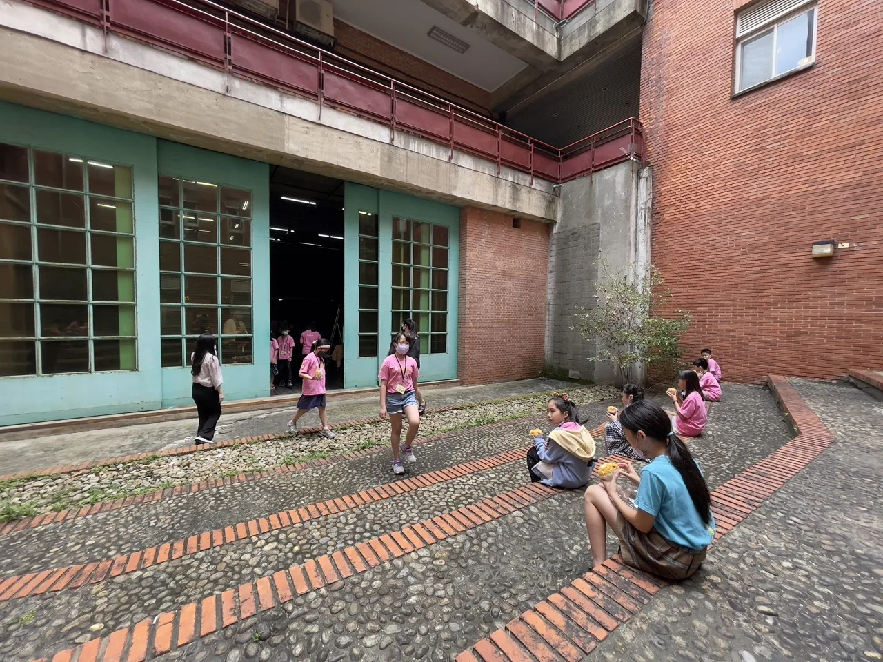 休息時間學生好開心，拿著點心到中庭台階享受片刻悠閒。莊勝鴻攝
