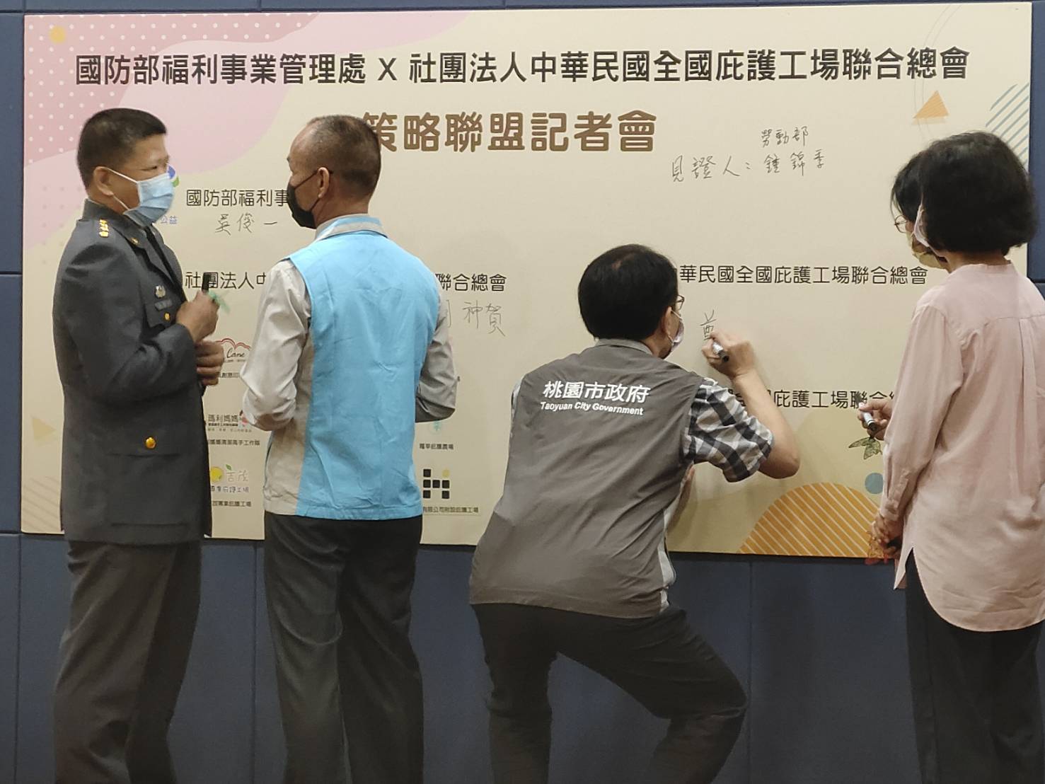 在立委湯蕙禎（右二）的促成下，今日一早，國防部福利事業管理處處長吳俊一上校（左一）與社團法人中華民國全國庇護工場聯合總會總會長胡神賀（左二），順利完成策略聯盟計畫簽訂儀式，現場並由桃園市政府勞動局局長吳宏國（左三）、勞動力發展署副署長鍾錦季（右一）、貴賓們及12家庇護工場店主，一起觀禮見證。蘇佑昇攝