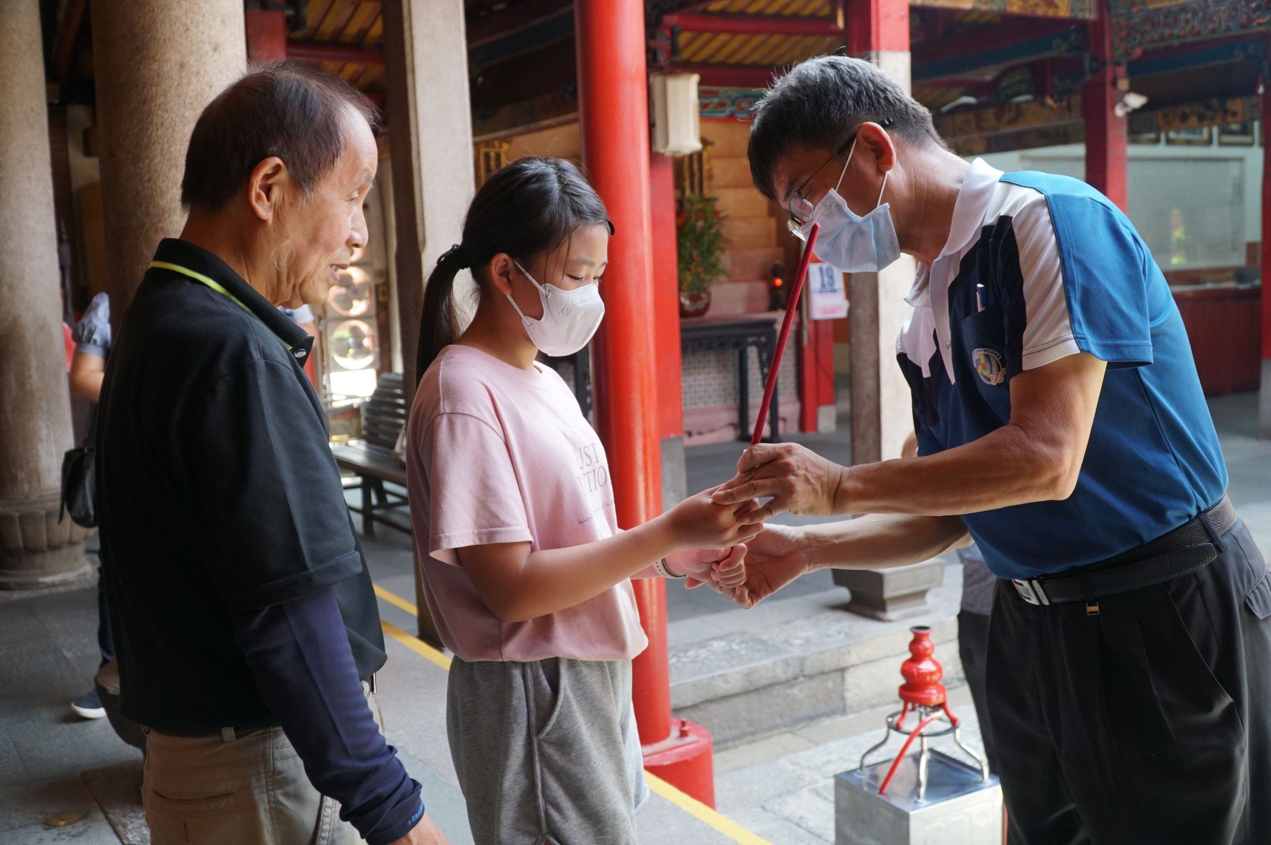 退休校長吳聲淼(右)指點將擔任禮生的學生,如何執香