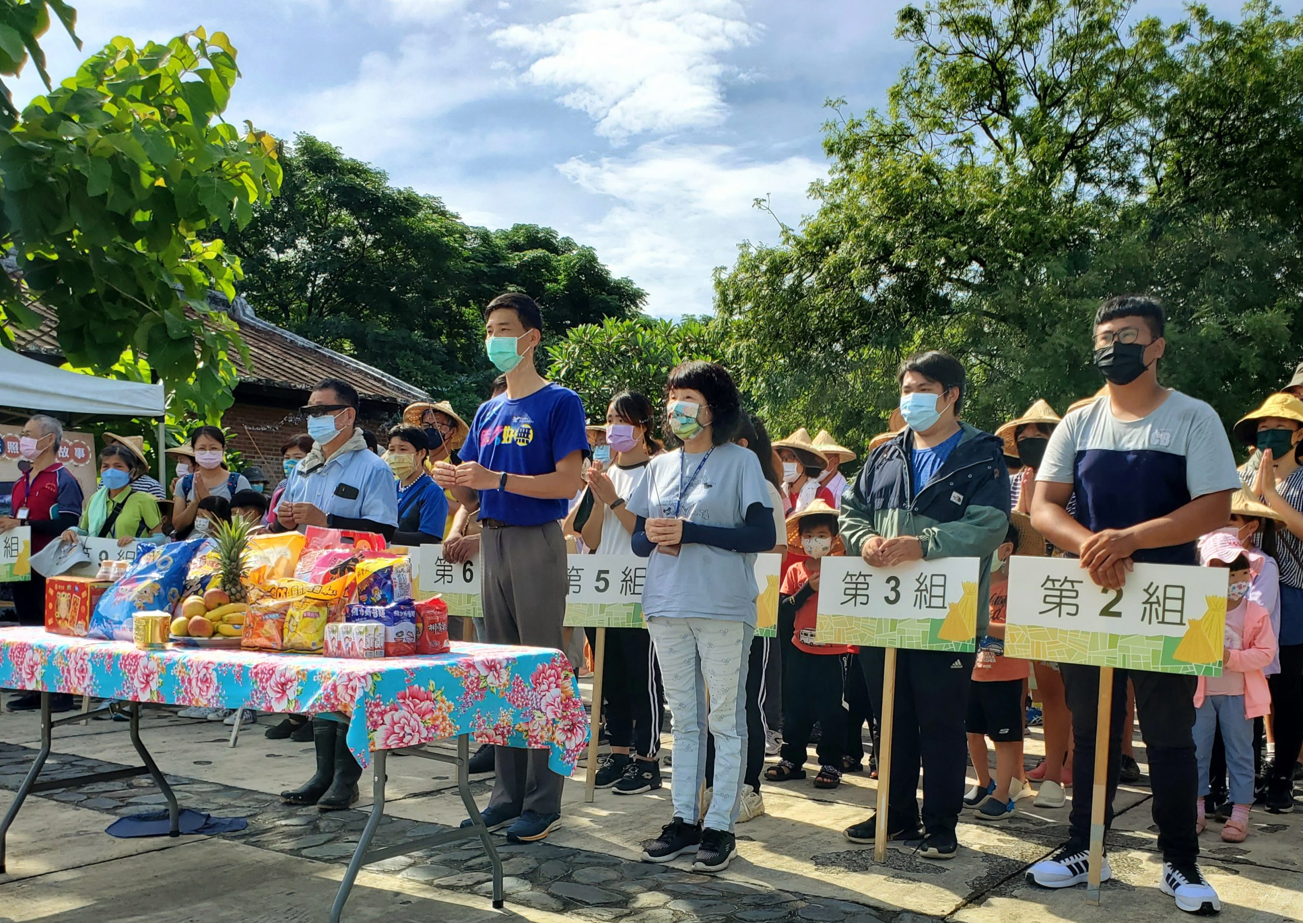 六堆園區割禾前全體參與民眾感謝田頭伯公保佑今年豐收（左起，農耕達人李恭錄老師，客發中心江盛來組長，六堆園區志工隊李竹芳隊長）