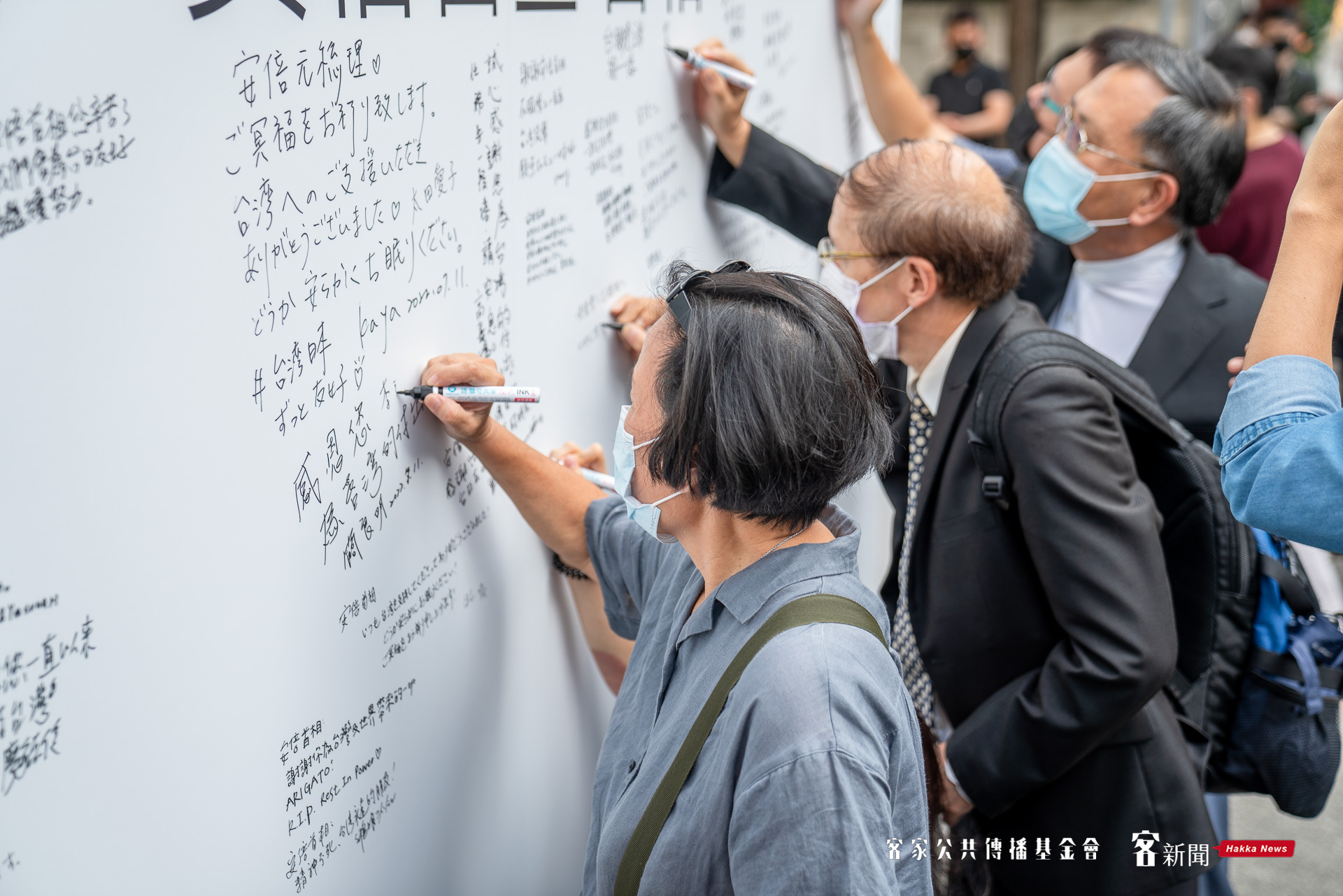 民眾在看板上尋找空位，並寫下追思留言。范修語攝