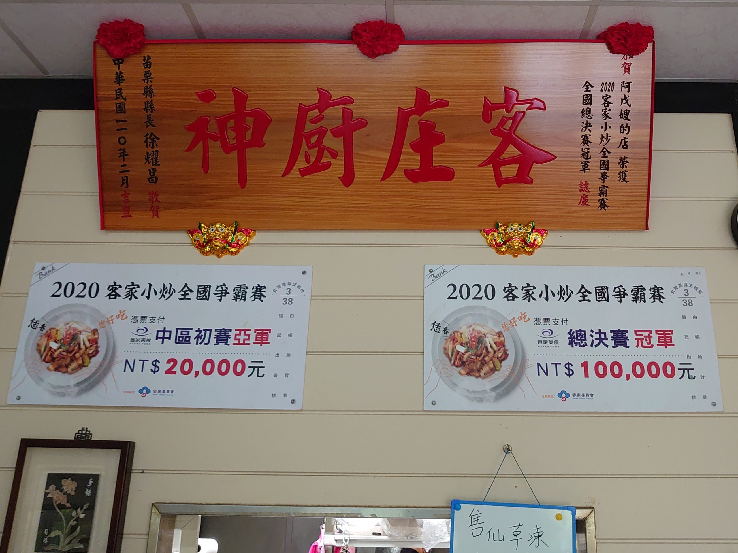 店內牆上掛著「客庄廚神」與客家小炒全國爭霸賽的看板。李台源攝