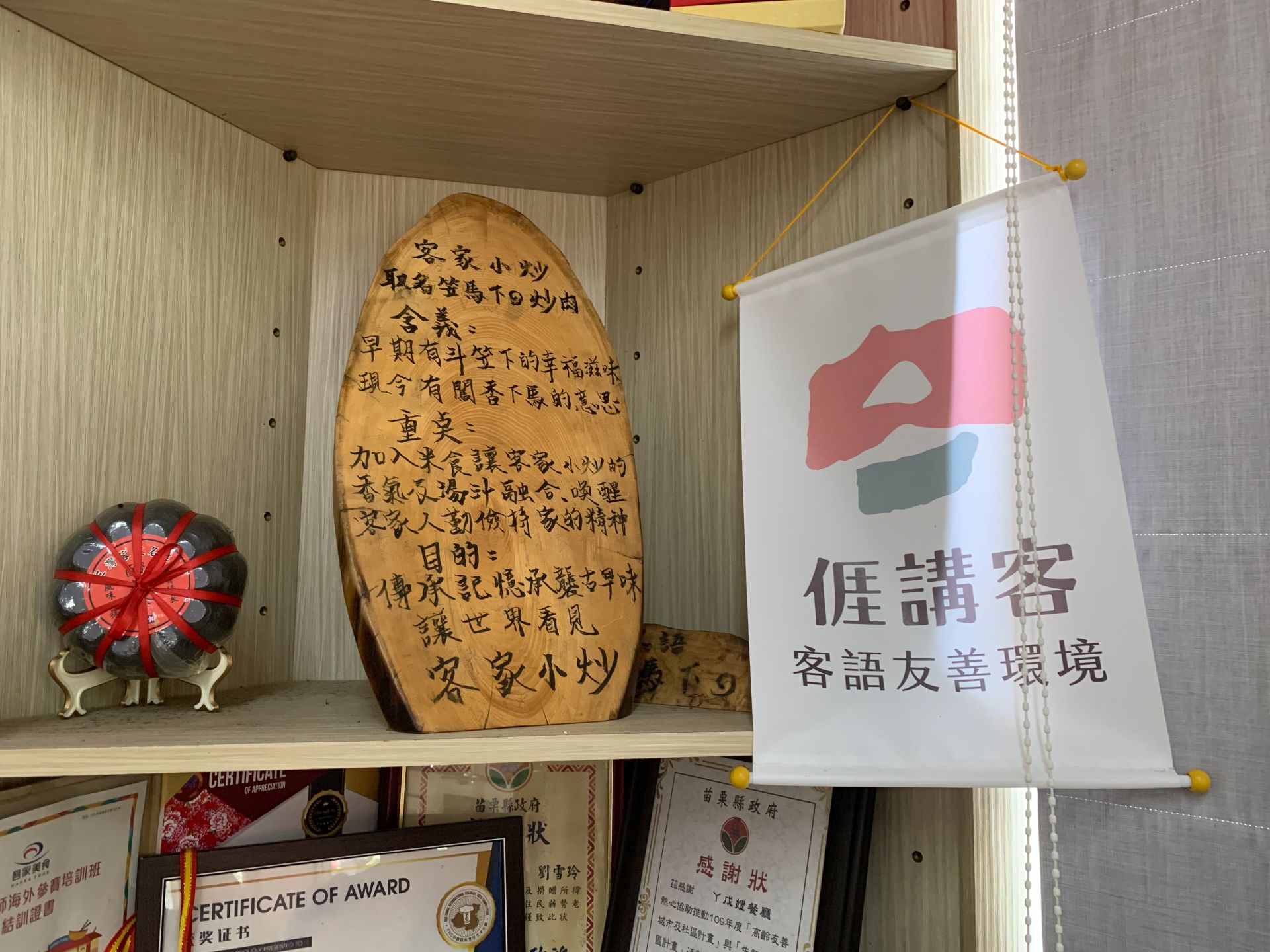 客家小炒的料理說明，底下可以隱約看見各式料理比賽獎狀。李台源攝