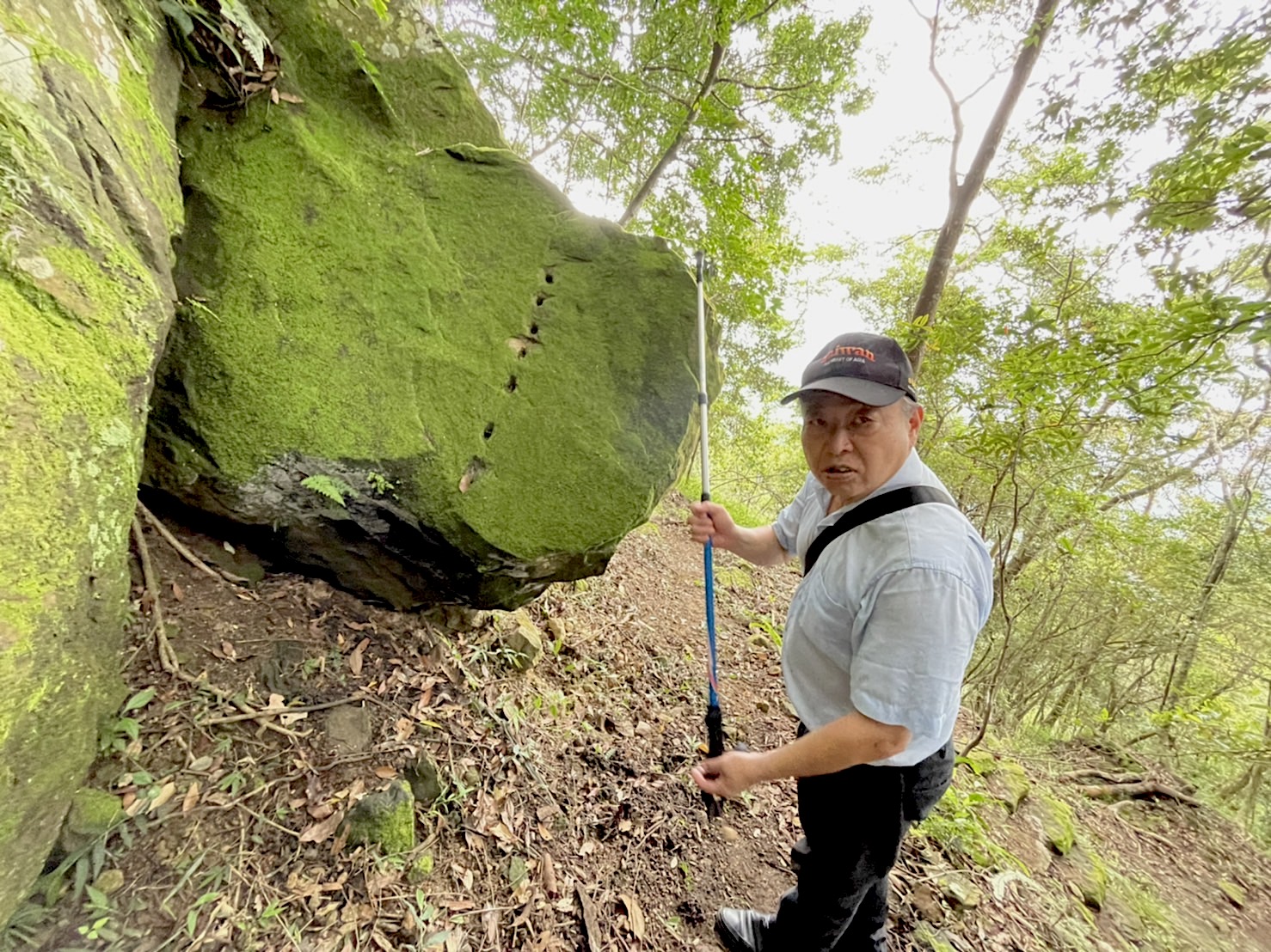 國姓鄉長丘埔生指著大石頭上的痕跡,解釋客家人過往的打石文化。楊靜茹攝