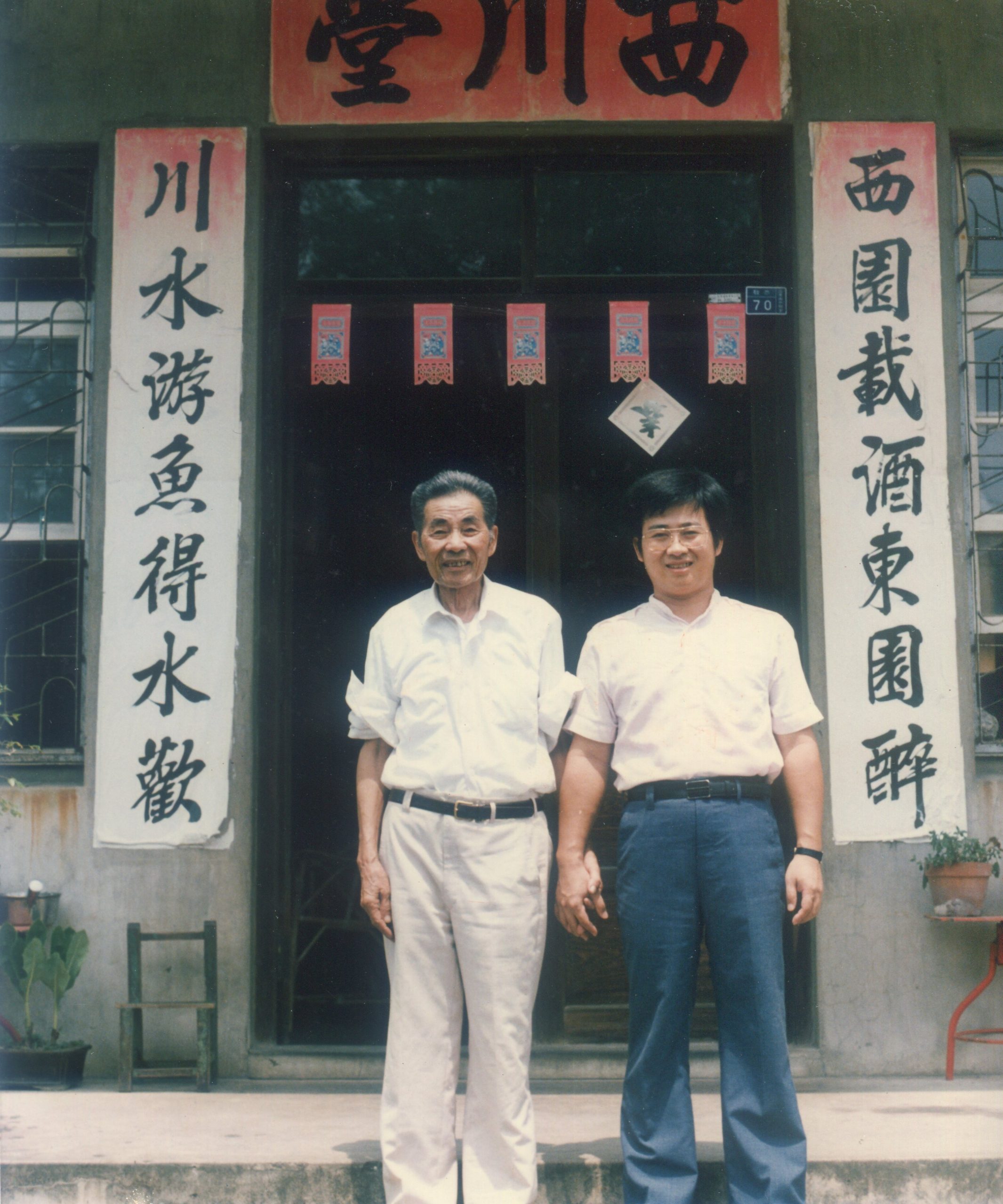 「苗栗詩仙」賴江質生前作了不少山歌歌詞，圖為他與孫子賴煥城在老家合影，他書寫的門聯蒼勁有力。何來美攝