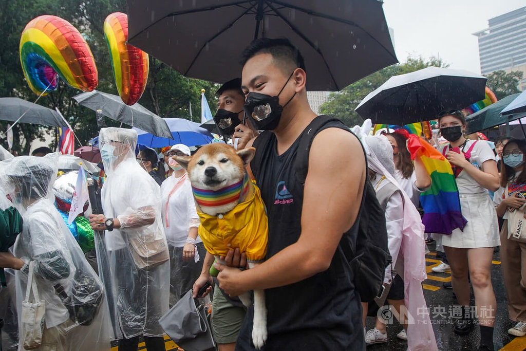 儘管天公不作美,仍吸引大批民眾到場響應參與台灣同志遊行,還有人特別為寵物戴上彩虹旗項圈,抱著愛犬冒雨前行。中央社