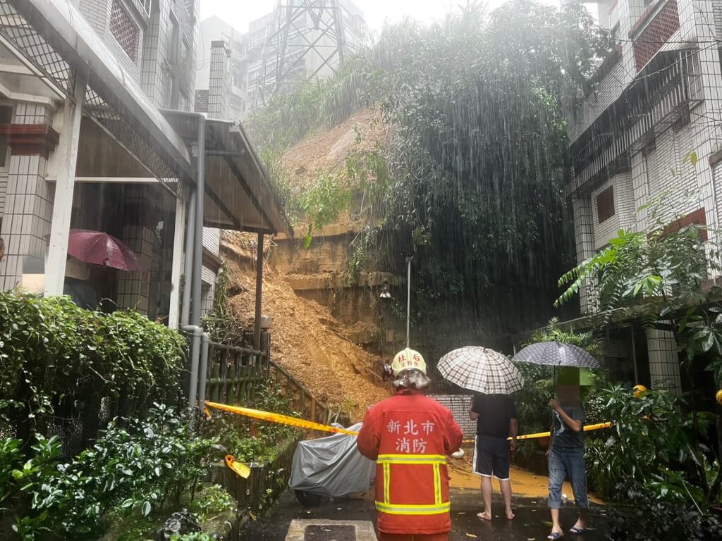 新北市汐止區伯爵山莊社區16日下午出現土石流與土石崩落，有住家陽台鐵窗遭石頭砸毀，目前社區內3戶共11人已撤離至社區活動中心。（翻攝照片）中央社