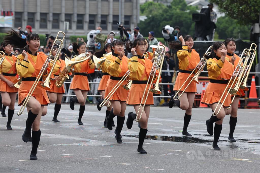 日本京都橘高校吹奏部團員表演伴隨吹奏樂聲，同時展現活潑舞步。中央社