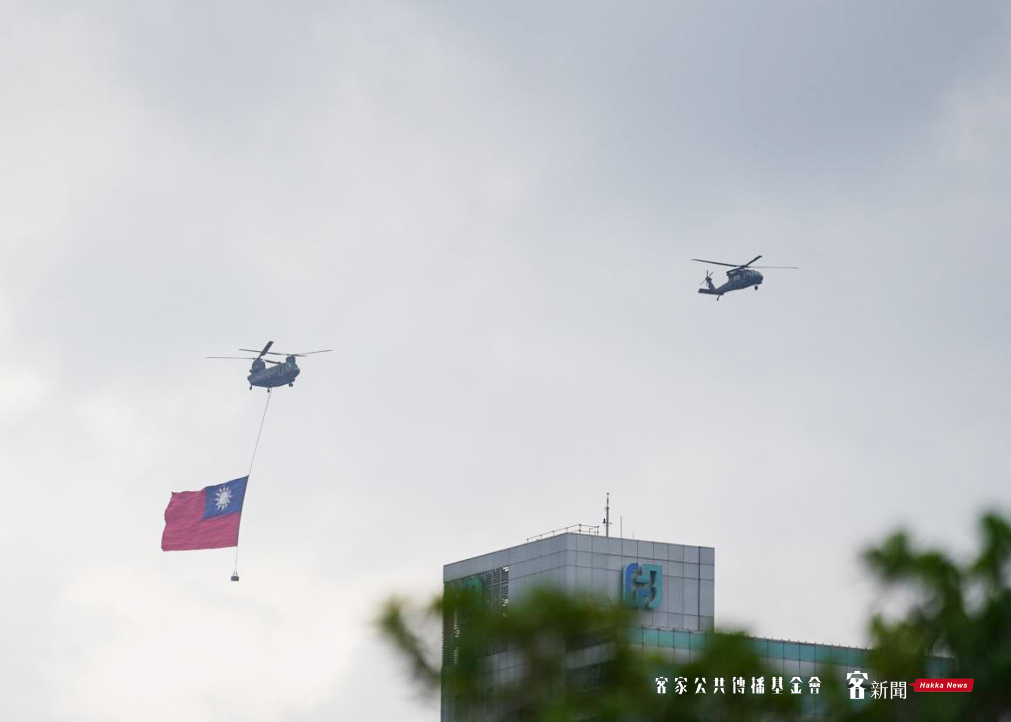 國軍CH-47SD契努克運輸直升機將吊掛巨幅國旗,在UH-60M黑鷹直升機引導及跟隨下,緩緩通過府前上空。洪俊傑攝