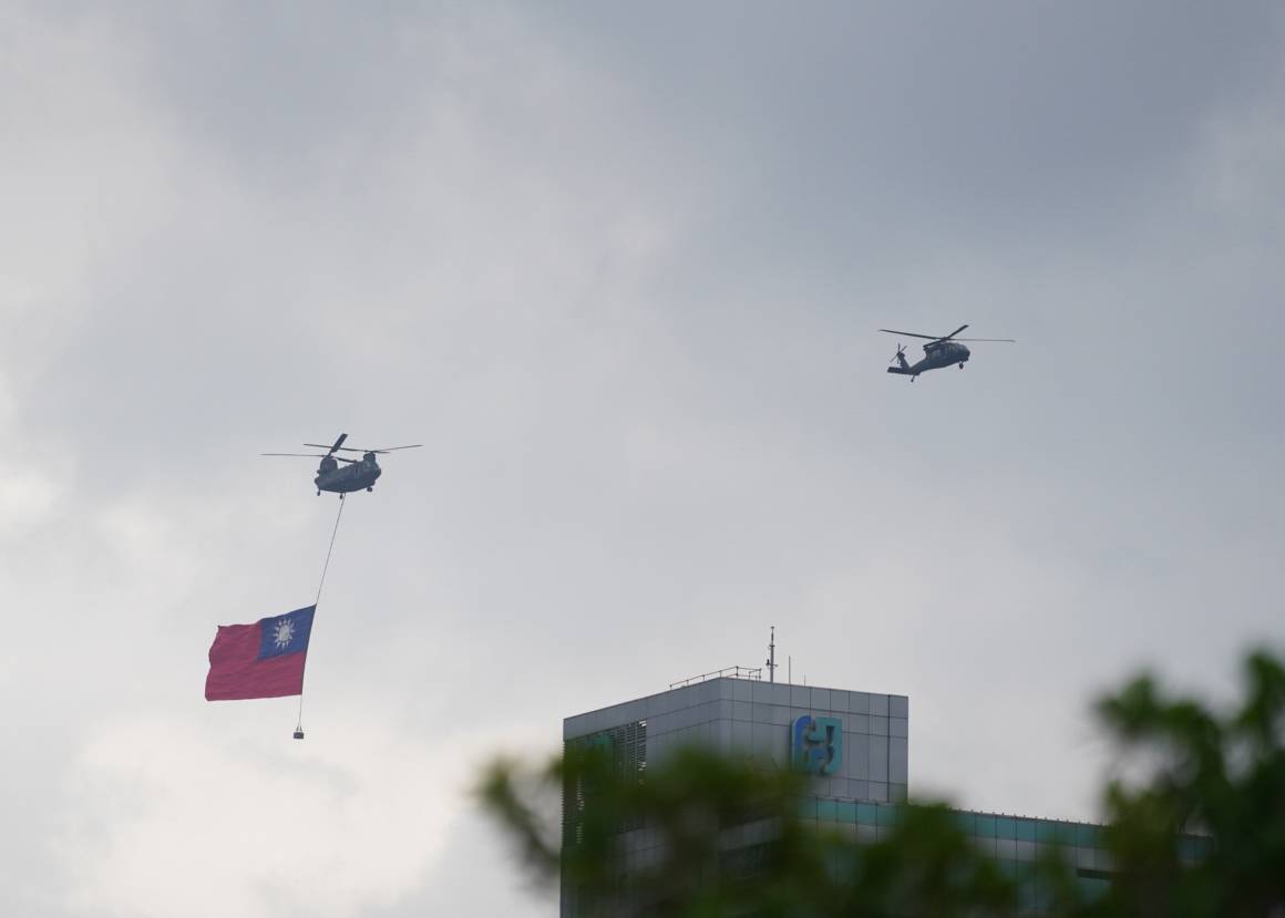 去年國慶國軍CH-47SD契努克運輸直升機將吊掛巨幅國旗,在2架UH-60M黑鷹直升機引導及跟隨下,緩緩通過府前上空。洪俊傑攝