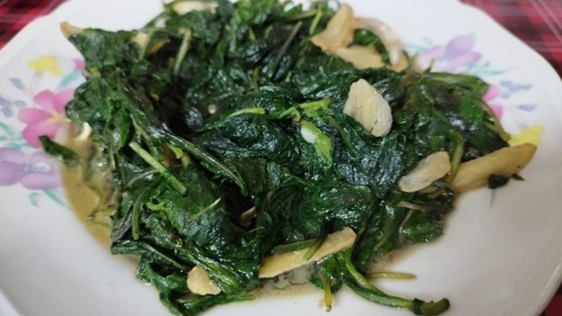 用麻油、薑絲、蒜仔來炒昭和草,毋使放忒多調味料,火烈烈炒兩下仔,苦甘苦甘个昭和草就好食了。鍾孝昇攝