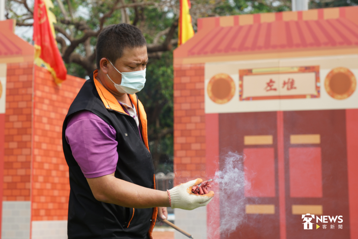 參賽者點燃手上鞭炮，準備投向砲籠。《客新聞》資料照