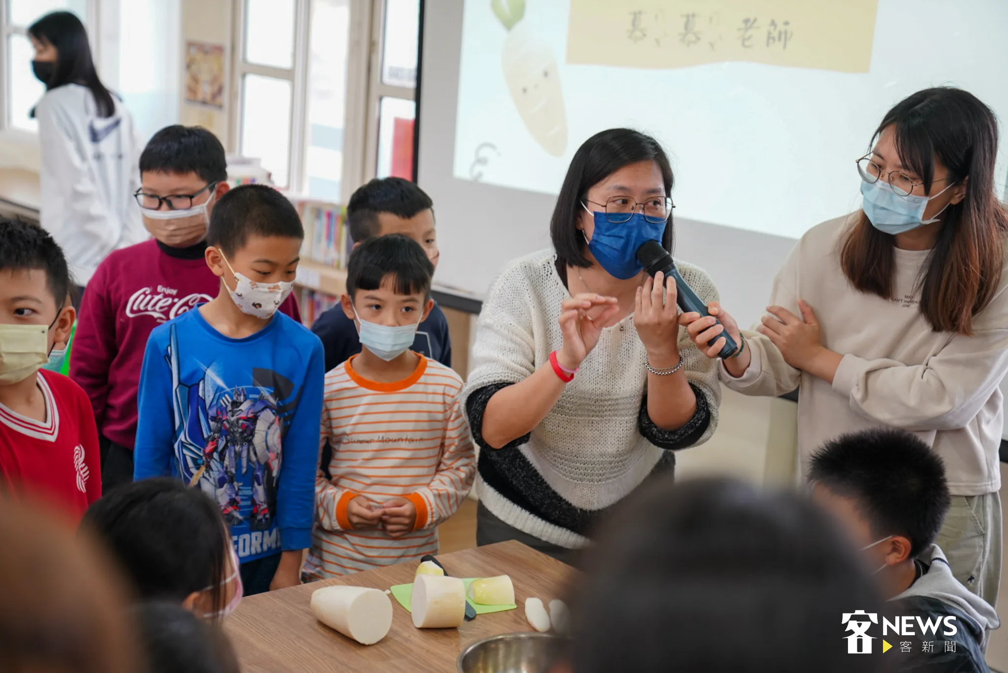 今天在南埔國小上醃漬課的老師陳慕貞（右二），細心地向孩童們解說醃漬蘿蔔的課程。
