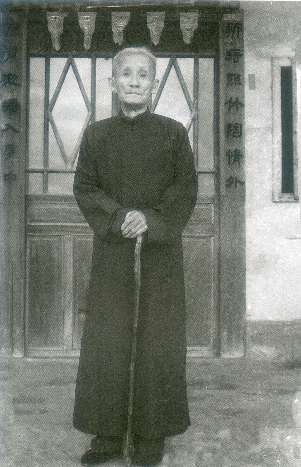 1961年謝長海在銅鑼芎蕉灣老屋前留影,門聯「聊將絲竹陶情外,猶有池塘入夢中」,亦是他所作。謝其煚提供