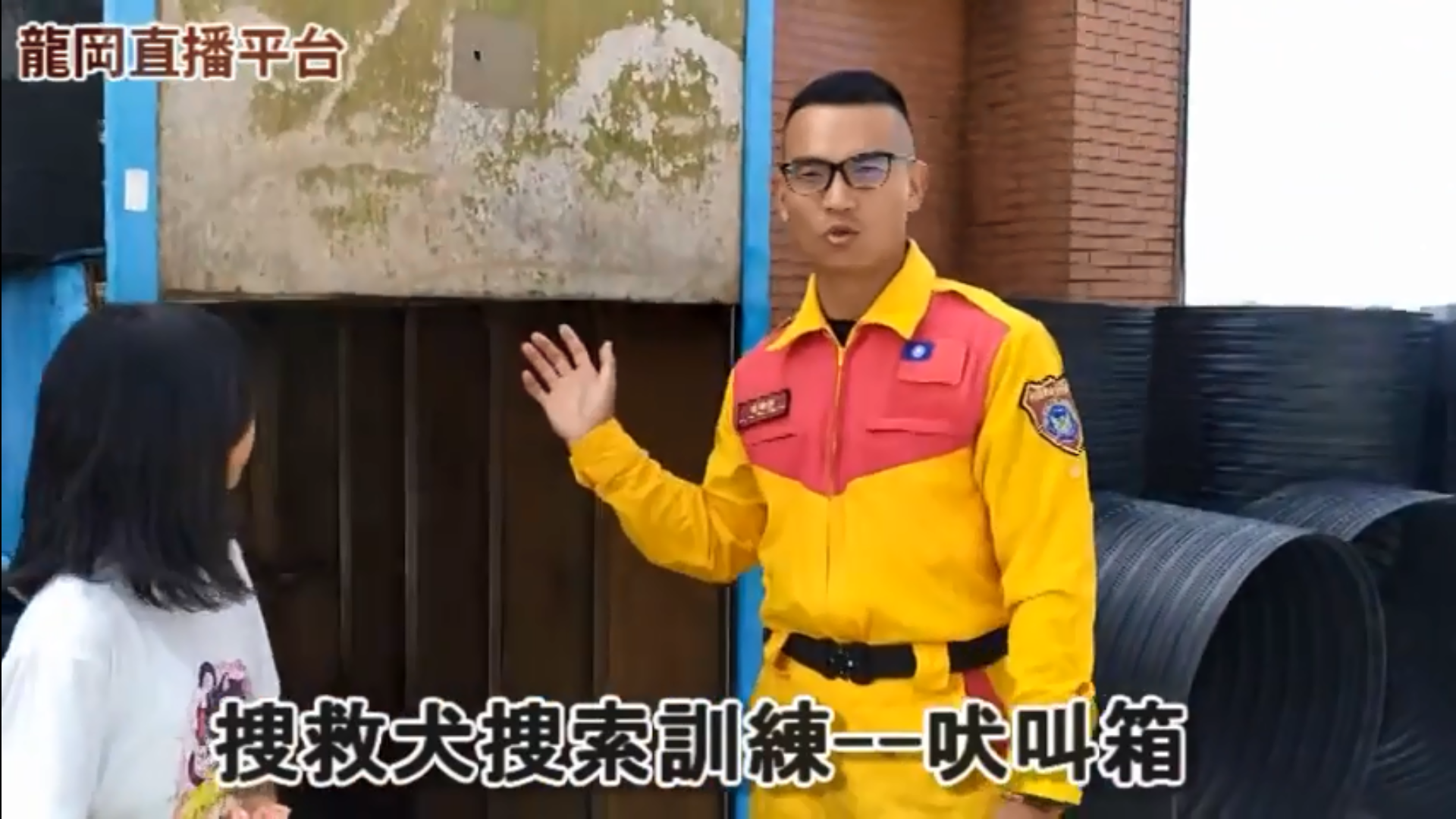 負責訓練Emma个領犬員吳曜任，使用吠叫箱摎Emma進行搜索訓練。作者提供