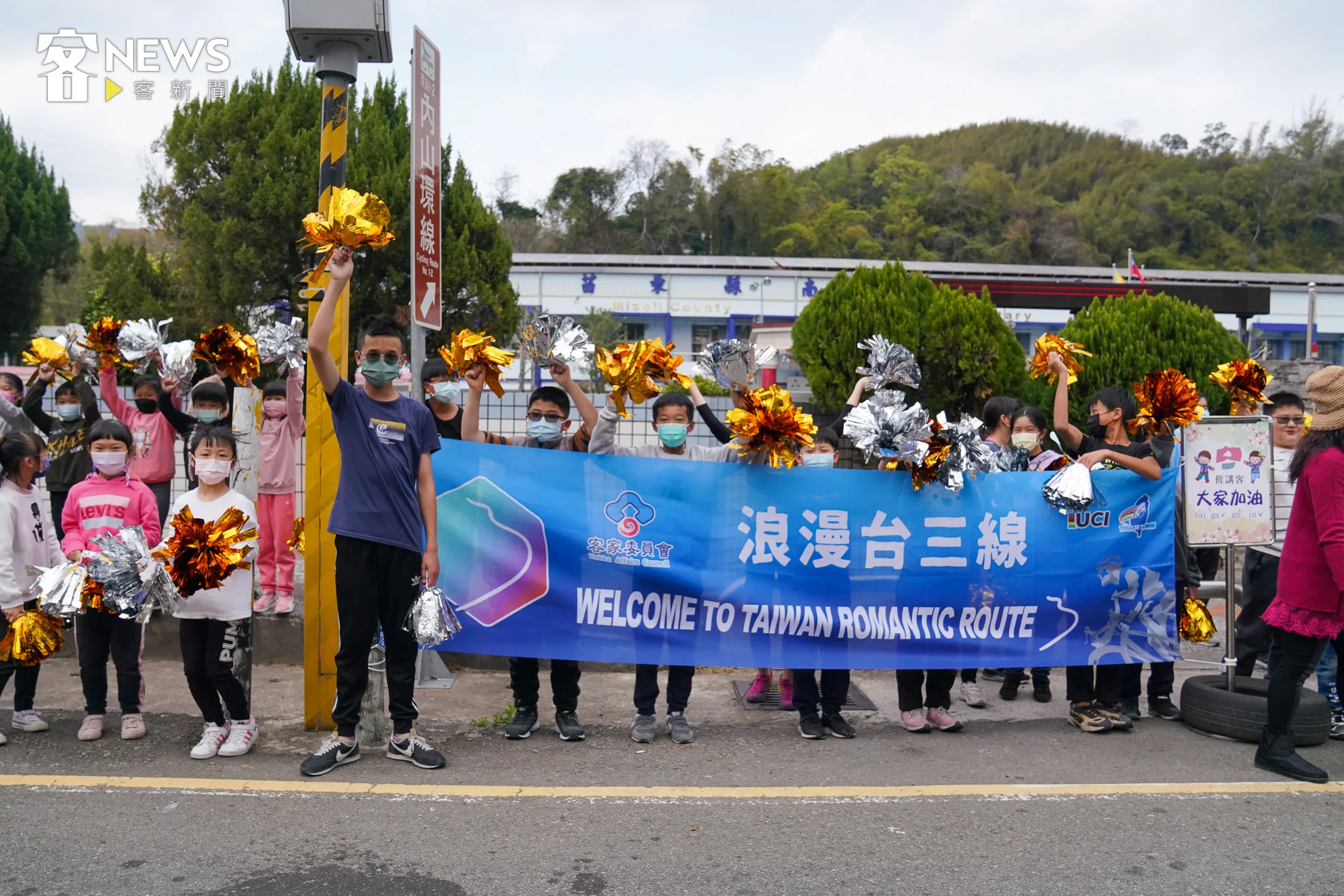 苗栗南胡國小學生高舉浪漫台三線布條替選手加油。李台源攝