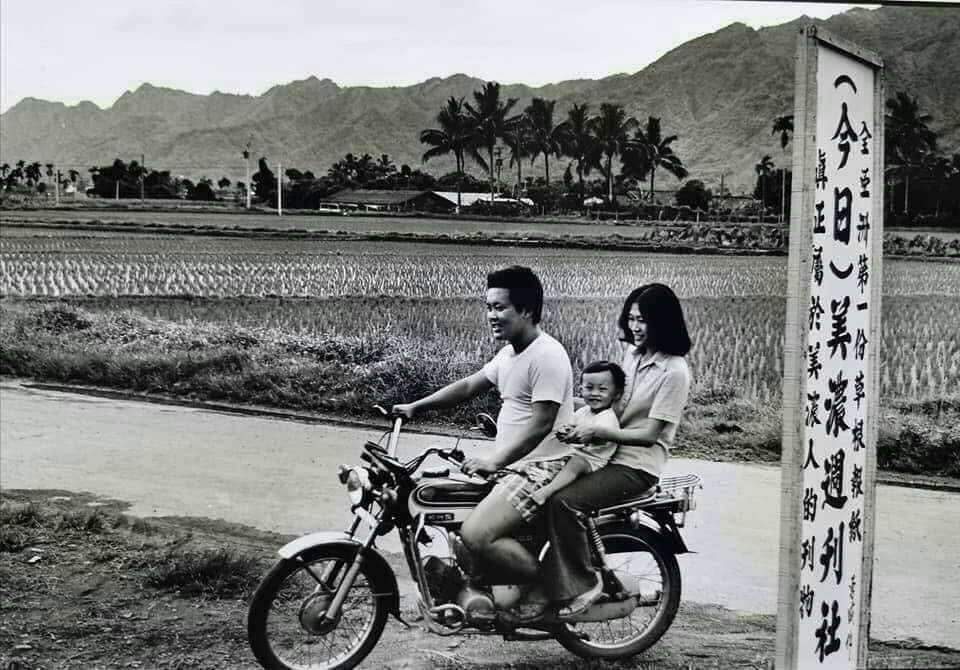 1977年黃森松在妻子林錦霜支持下回家鄉辦《今日美濃》週刊,圖為黃森松騎機車載妻子與長子經過週刊招牌的歷史鏡頭。黃森松提供