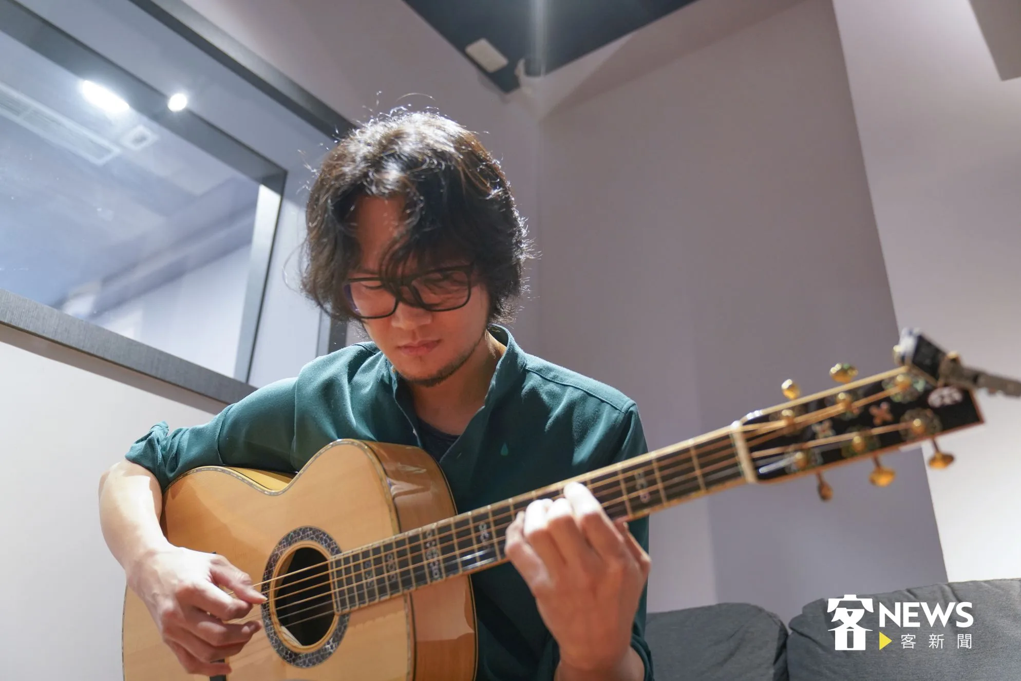 進錄音間之前，張仲麟先在休息區暖身彈奏吉他。洪俊傑攝