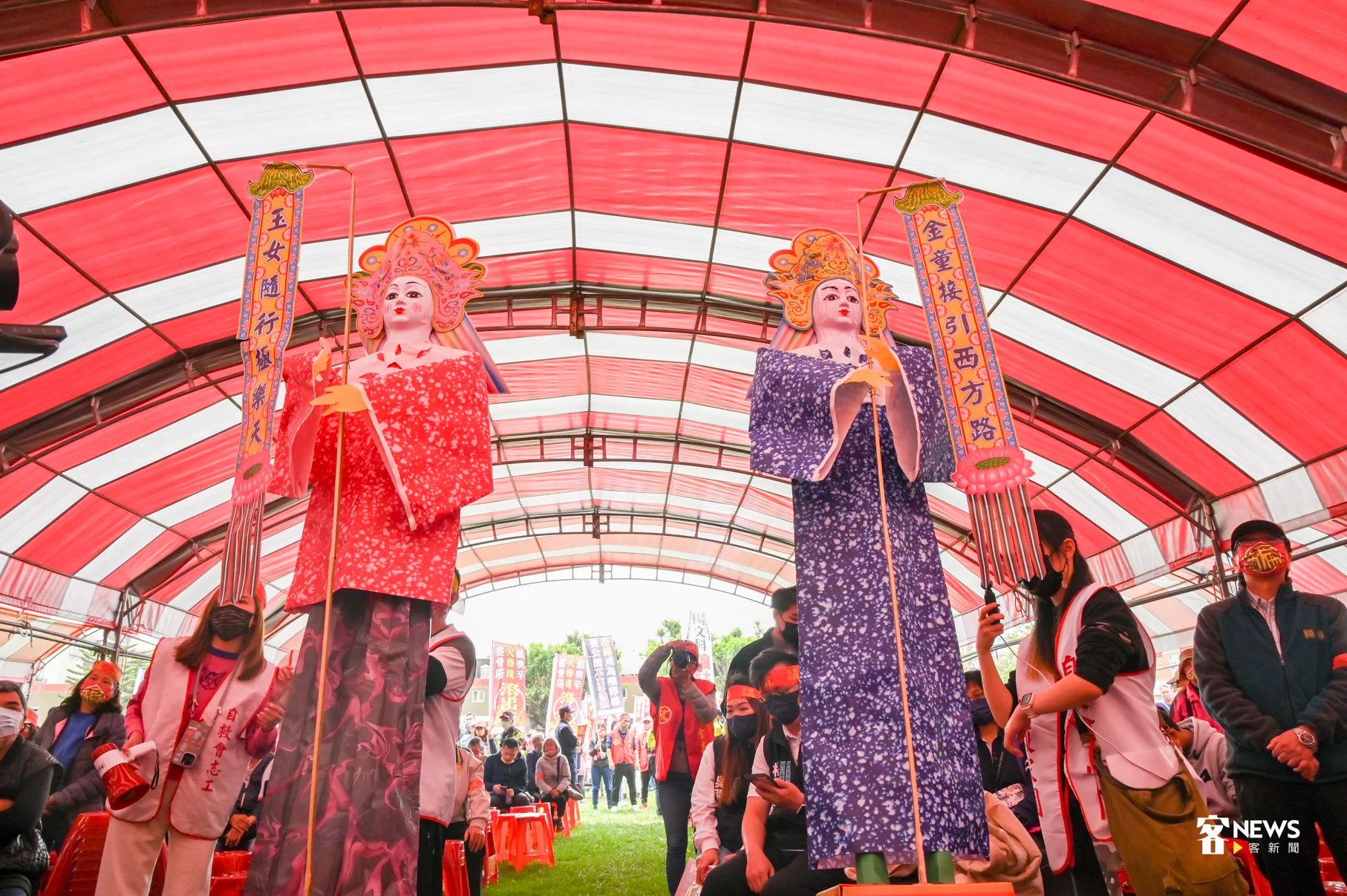 自救會志工披麻戴孝、高舉旗幡與捧著神祖牌與金童玉女紙紮人,上演一段「行動劇」。洪俊傑攝