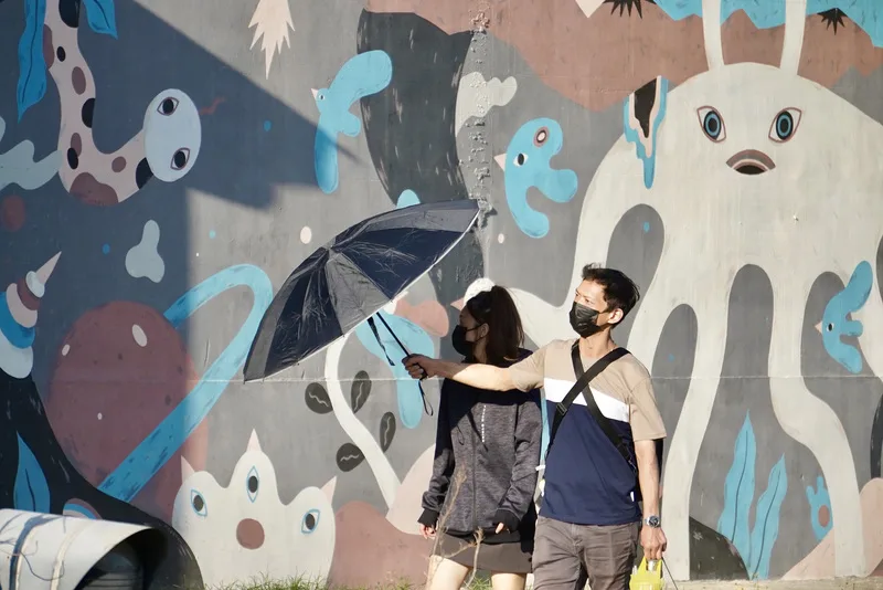 氣候異常，近年來夏季溫度逐漸升高，戶外活動的民眾必備傘遮陽防曬。中央社