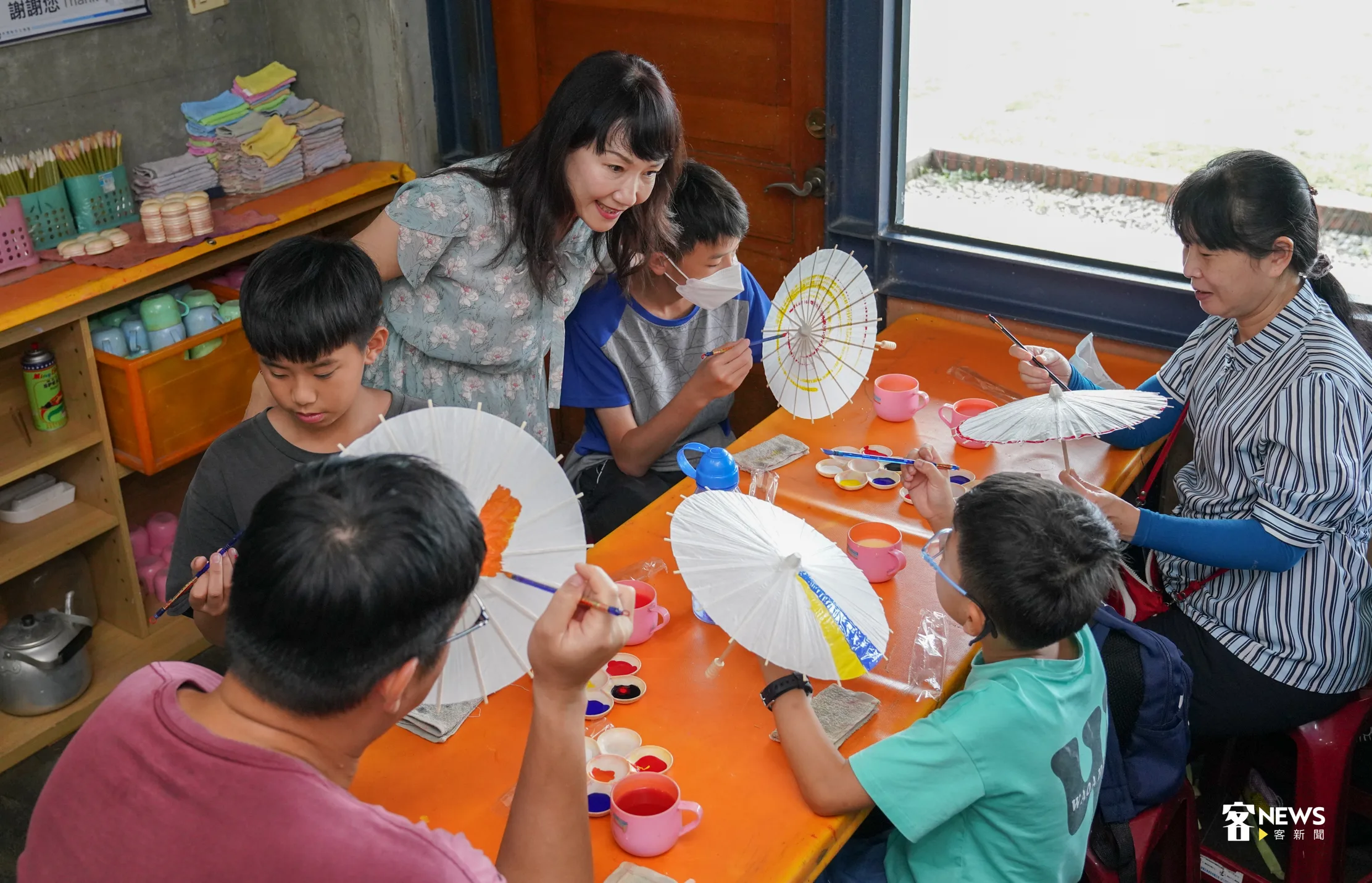 高雄市客委會主委楊瑞霞(圖中站立者)至DIY紙傘教室與參加輕旅行的小朋友寒喧問候。洪俊傑攝