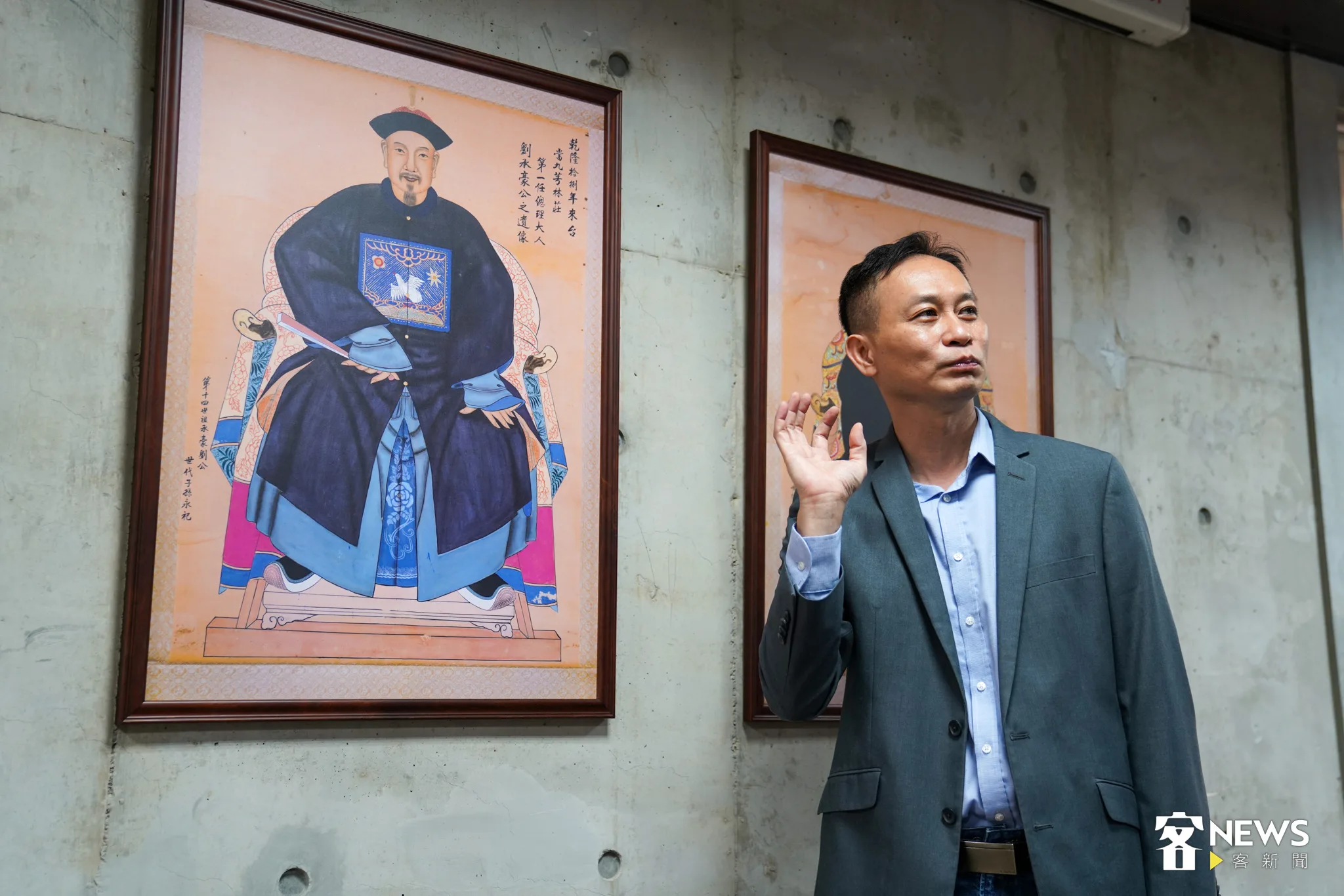 身為劉承豪後代子孫的芎林鄉代劉名揚站在祖先畫像前，兩者樣貌有幾分相似之處。范修語攝