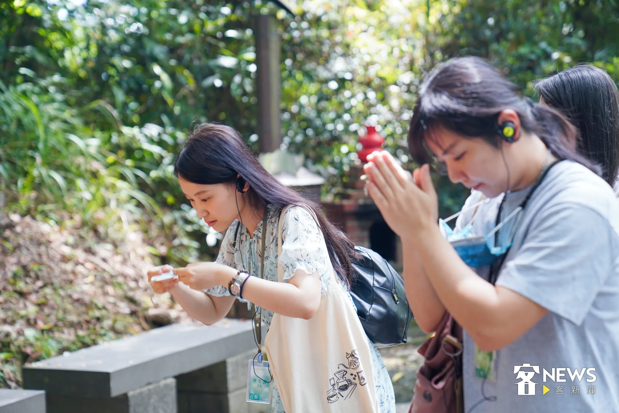 民眾拿著野薑花手抄紙平安符，虔心參拜。范修語攝