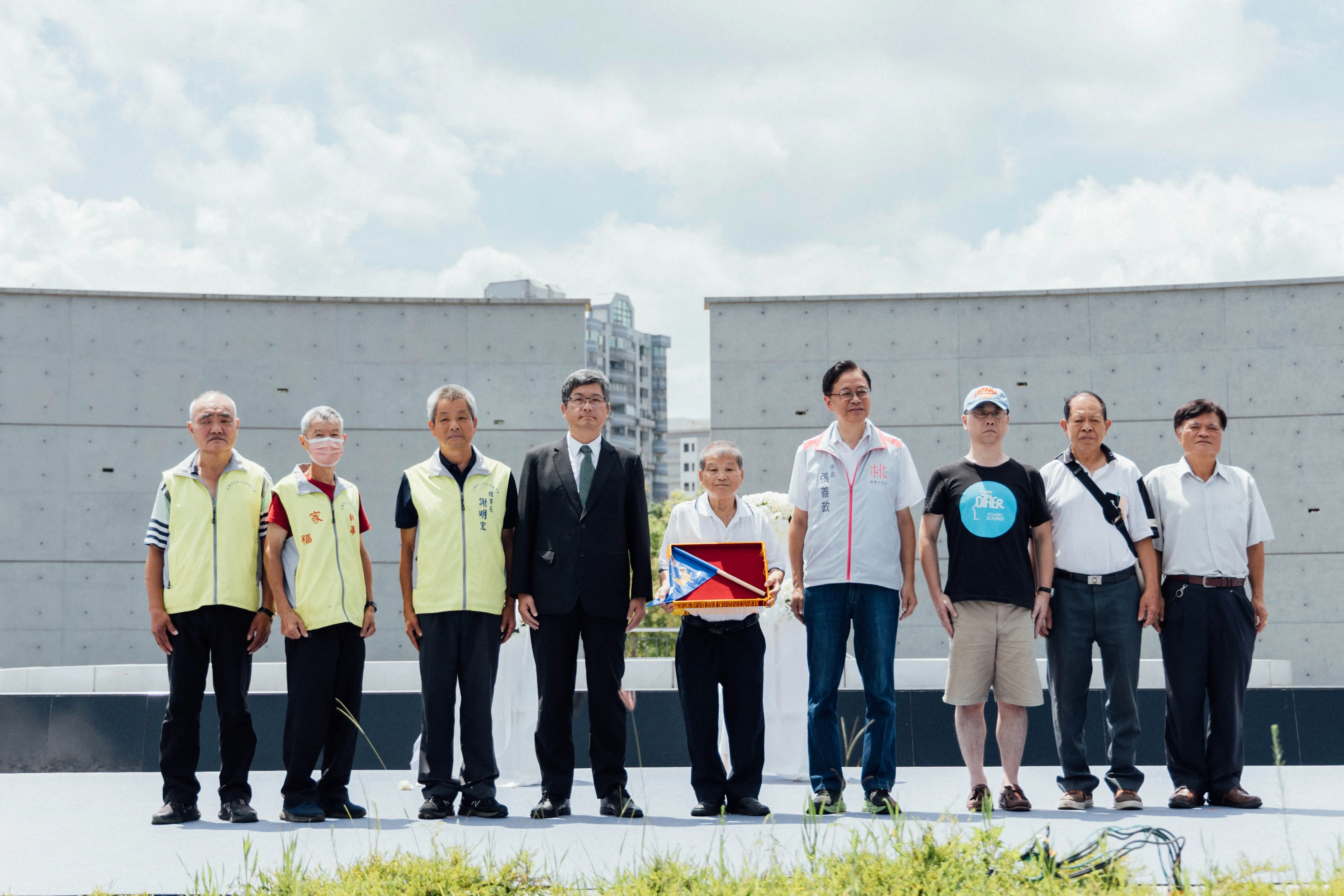 由客委會主委楊長鎮與桃園市長張善政一起致贈藍地黃虎旗予當年戰役中犧牲的先烈遺族。客委會提供