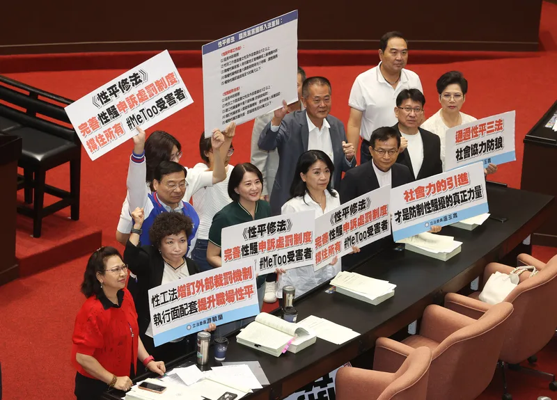 立法院31日三讀修正通過性別平等工作法部分條文，增訂權勢性騷定義並分層罰，最重處新台幣100萬<br />元罰鍰，懲罰性賠償最高5倍。圖為國民黨立委在議場內持標語看板合影。中央社