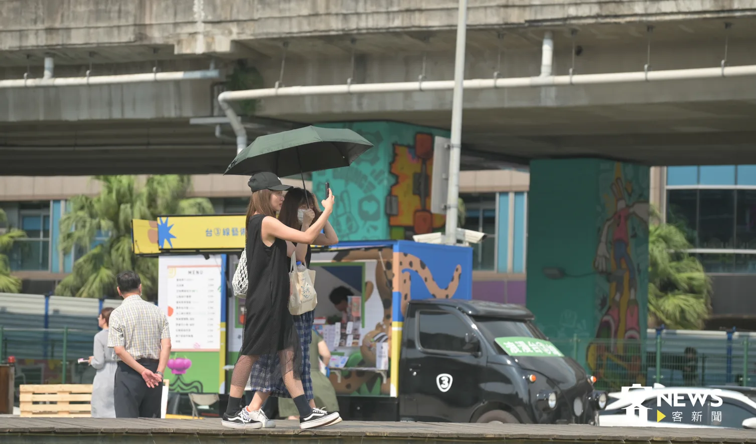 炎熱天氣，出外民眾隨身攜帶陽傘遮陽。洪俊傑攝