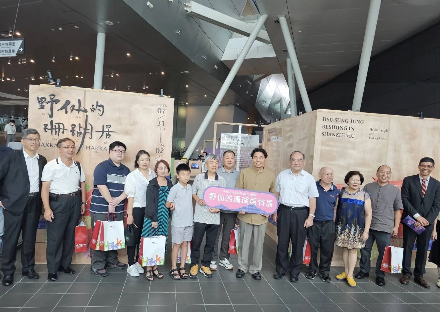 「野仙的珊瑚居-HAKKA人與HAKKA樂展」展場貴賓合影,傳藝中心副主任鄒求強(右六)、旁為國史館臺灣文獻館館長張鴻銘(右五)、音樂家徐松榮的家眷(右七起),左1為客委會主委楊長鎮、右1為客發中心主任何金樑。客發中心提供