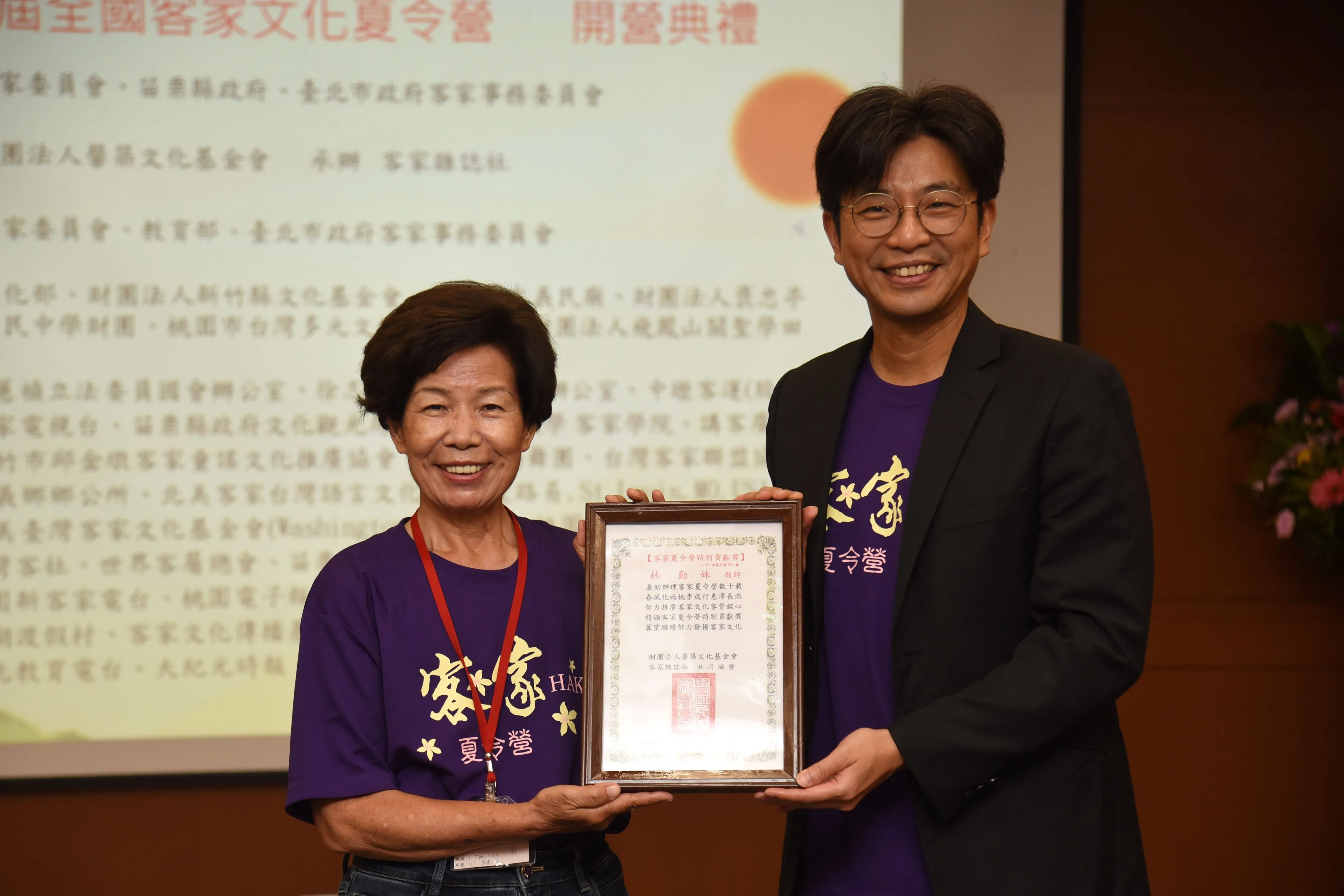 客委會副主委周江杰頒發夏令營特別貢獻獎，表揚客家文化夏令營營歌作詞作曲人林勤妹，肯定其對客家文化傳承的重大貢獻。苗栗縣府提供