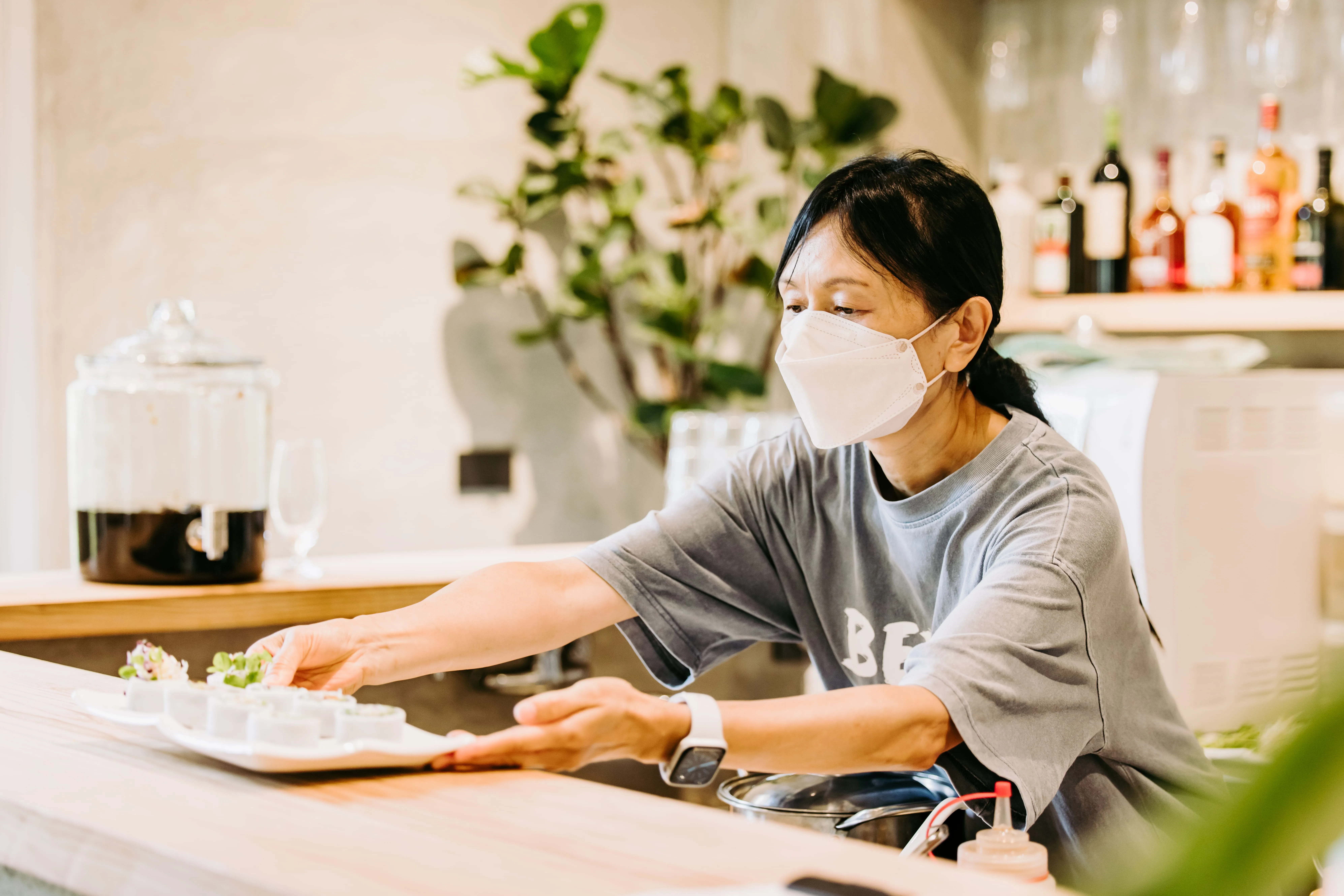 創辦人劉美熙正在吧台前料理食材、準備出餐。鴻梅文創志業股份有限公司提供
