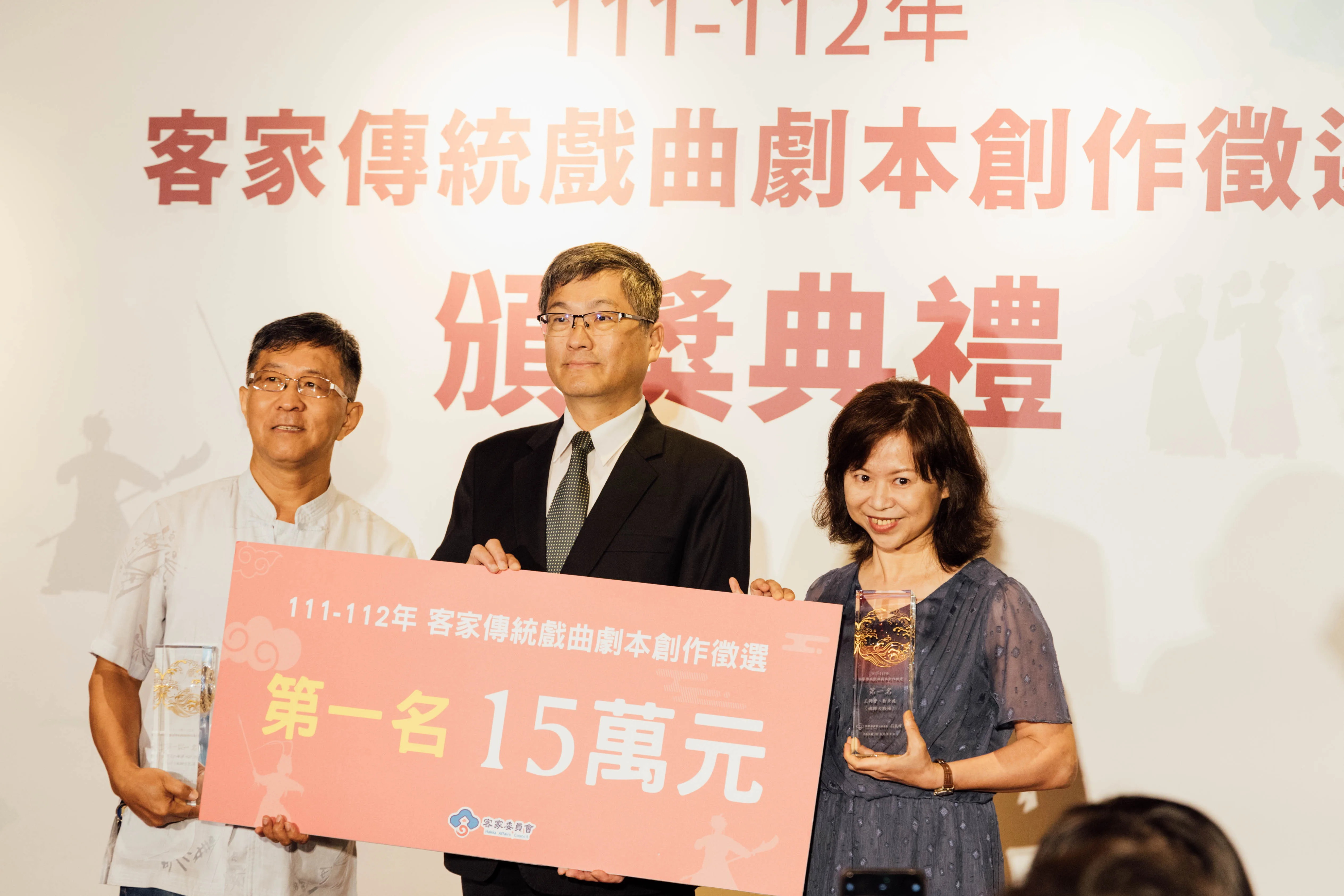 楊長鎮頒發獎座及15萬元獎金予第一名〈魂歸古戰場〉得獎者，得獎文本內容以大園航空城與閩客械鬥事、路祭文化相結合創作而成。客委會提供