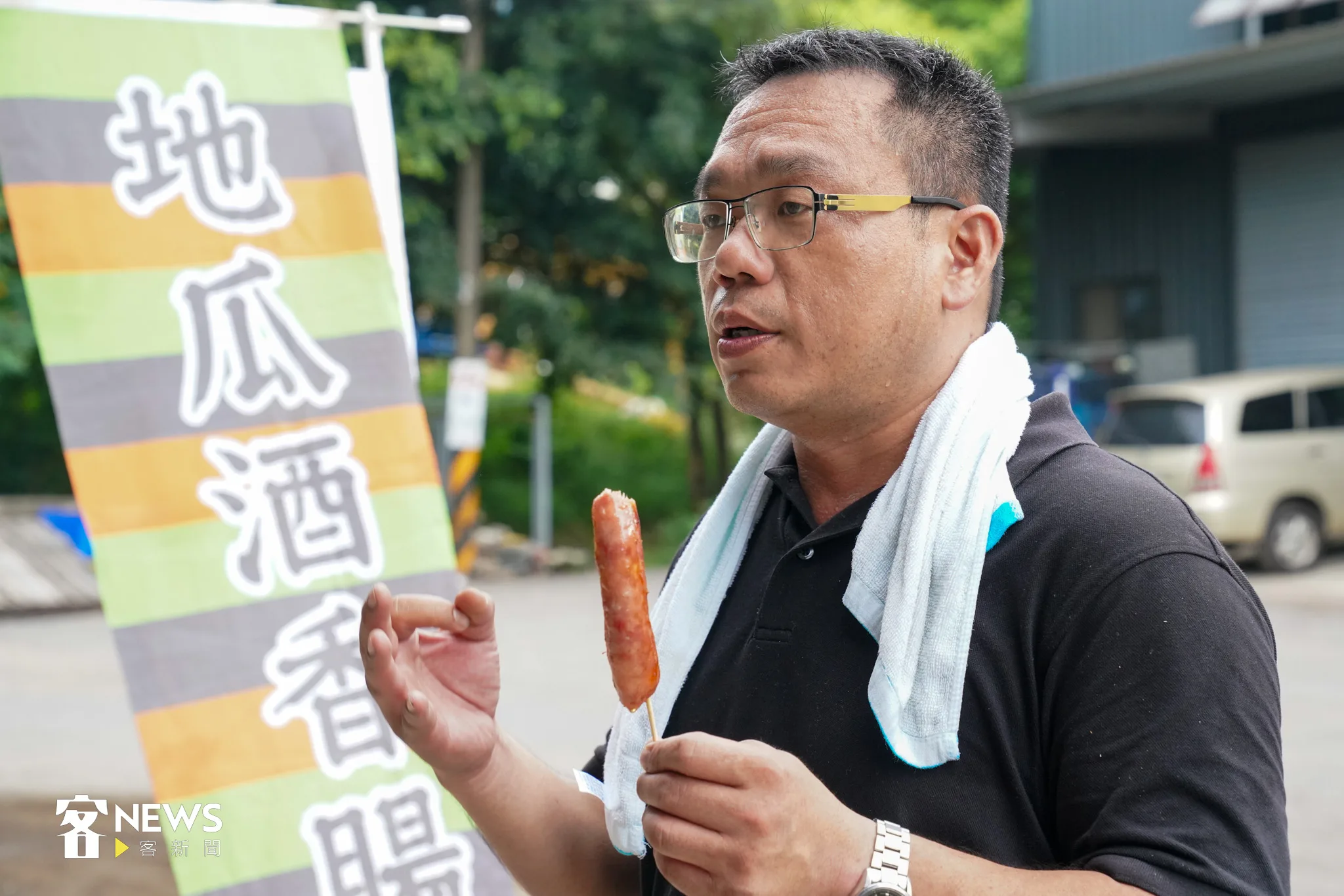 羅己能很開心的跟記者分享酒展賣地瓜酒香腸,生意意外的熱烈。宋佩遙攝。