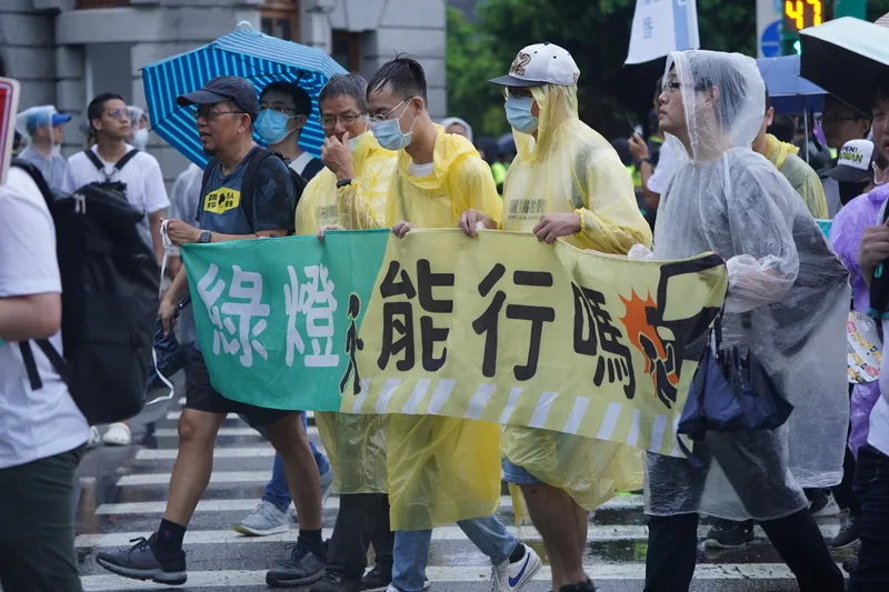 路權團體「行人零死亡推動聯盟」20日下午舉行「還路於民大遊行」，儘管現場一度下起滂沱大雨，仍有大批民眾到場響應，與會者沿途拉布條。中央社