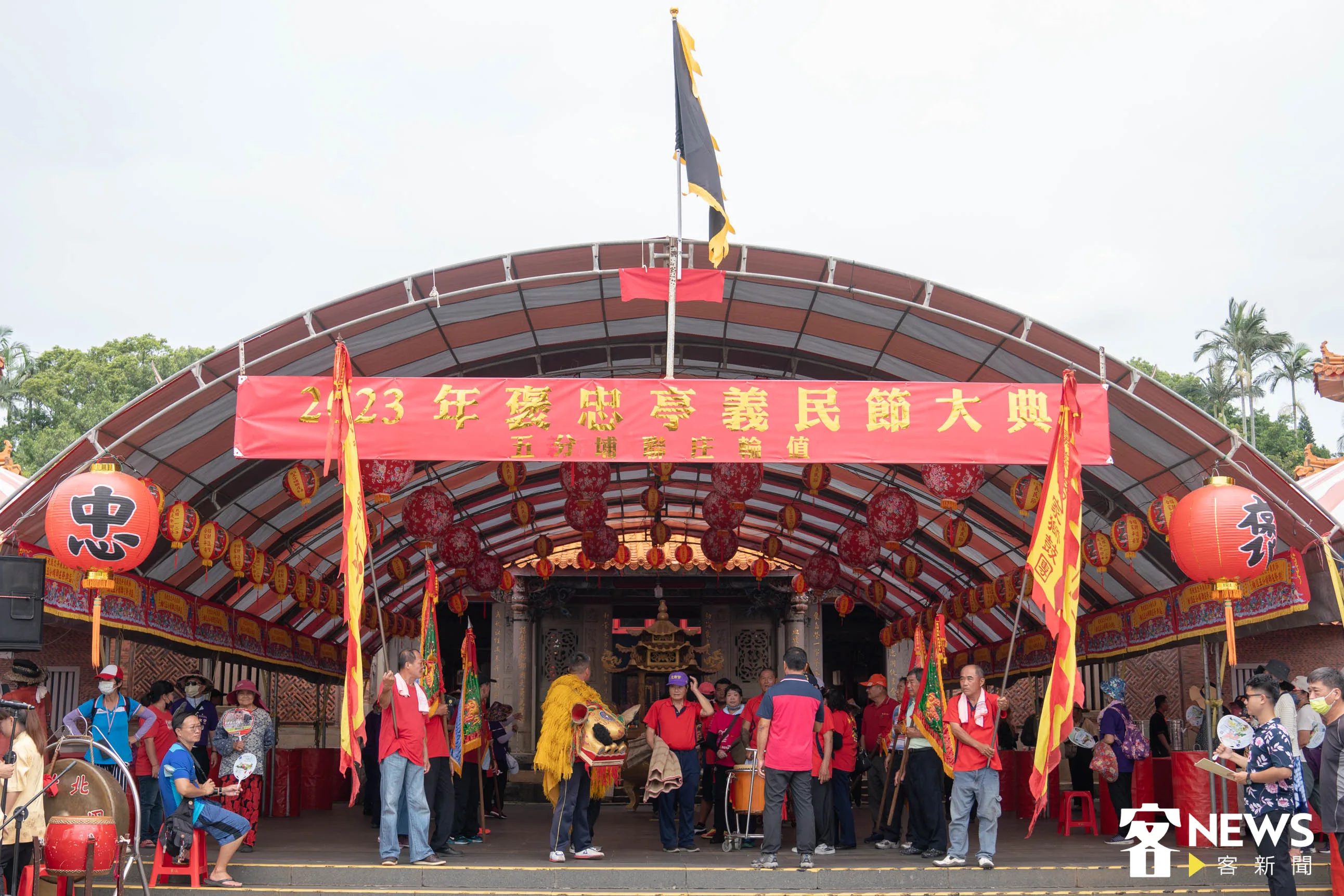 義民祭廟坪搭建的遮雨棚，上方懸掛著具有代表性義民祭典的「黑令旗」。洪俊傑攝
