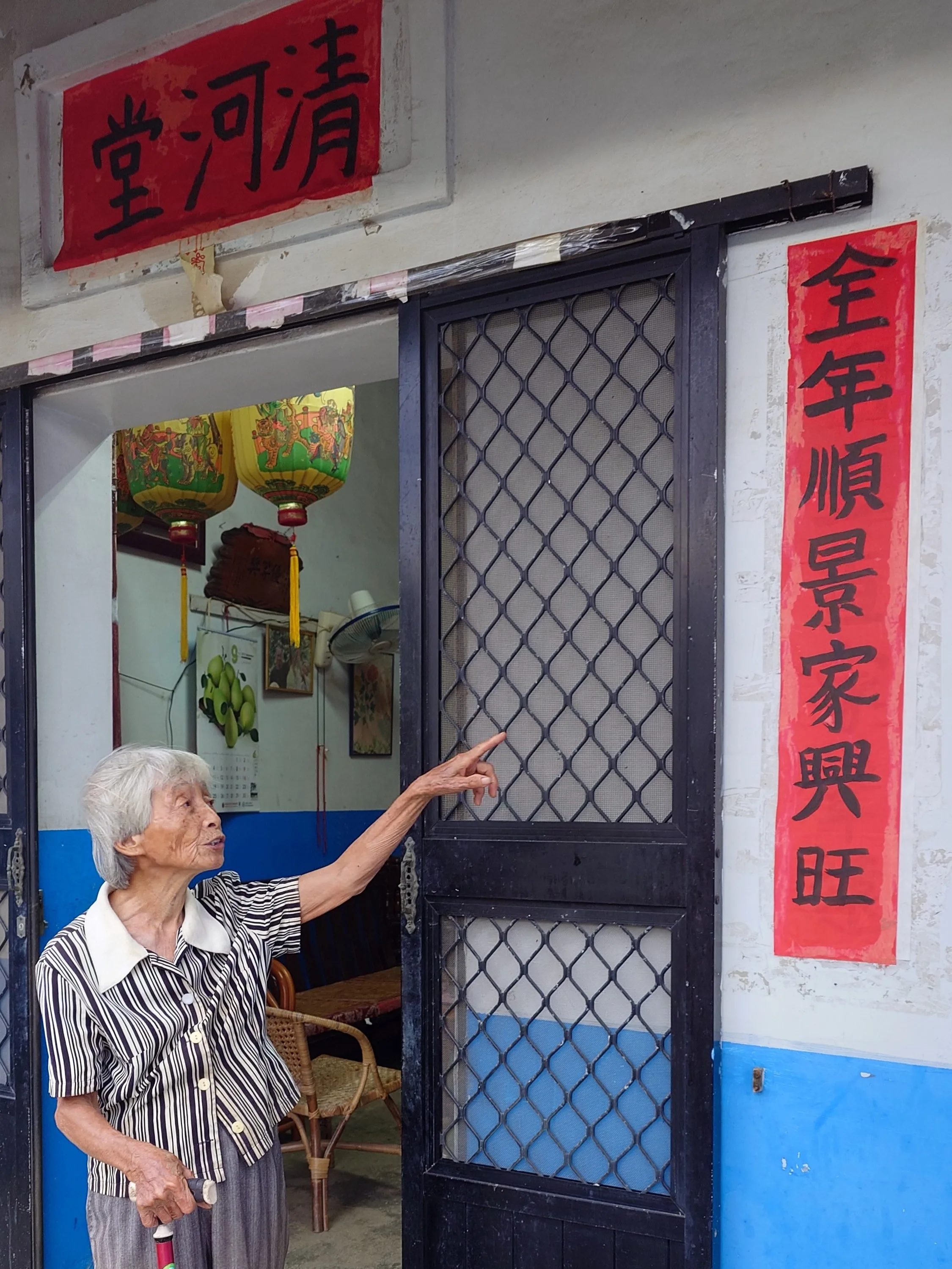 張四妹在老伴辭世對年後,重寫門聯「全年順景家興旺」,愛家之心溢於言表。何來美攝