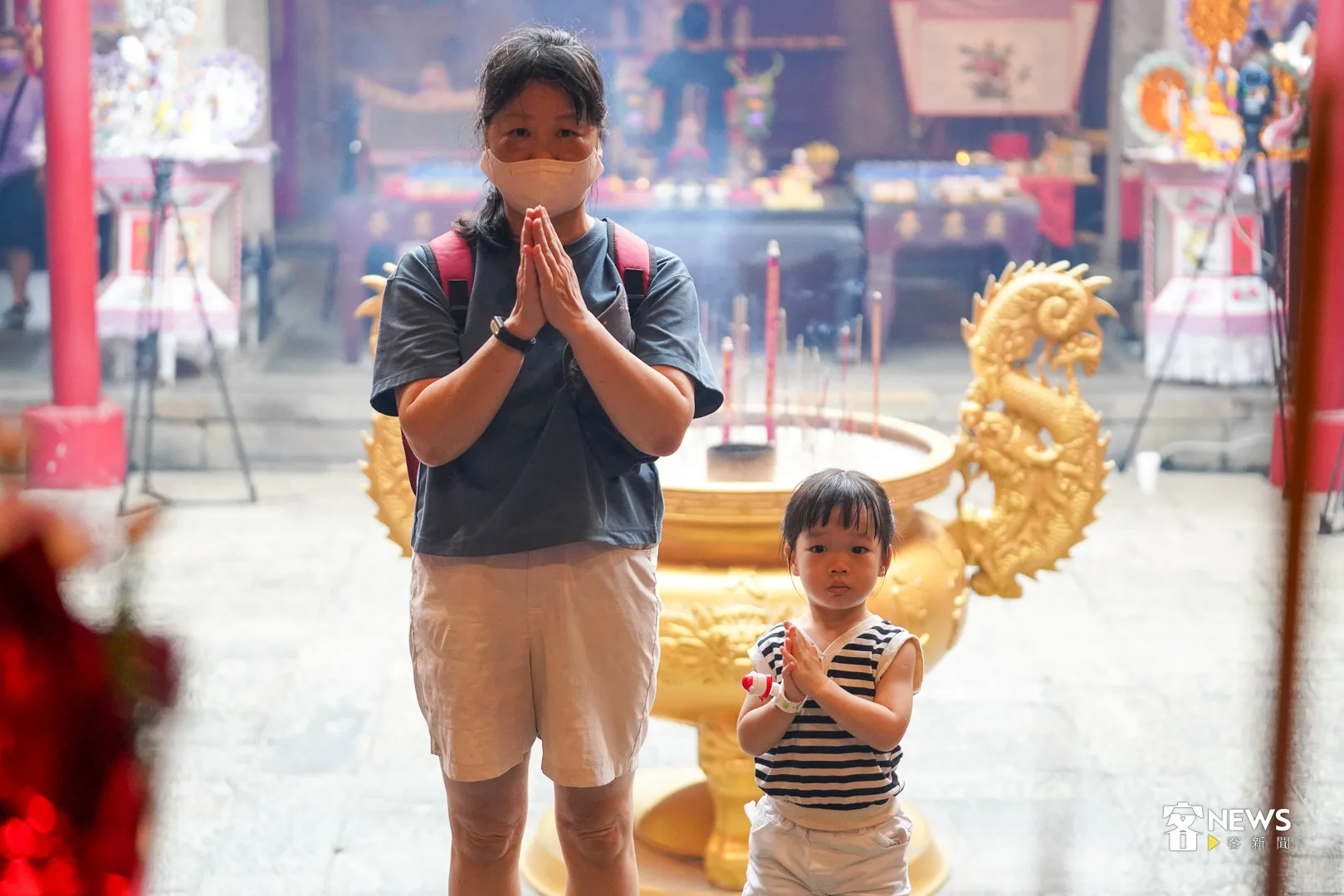 當地民眾帶著小孫女一起到義民廟祭拜，代表著傳統祭典急欲新世代的加入，在新舊之間傳承百年文化。何柏均攝