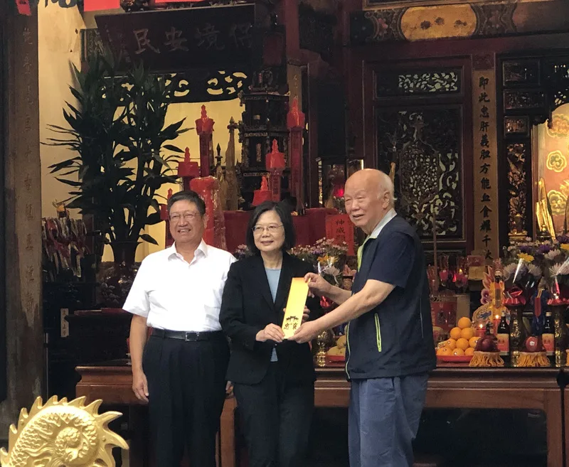 總統蔡英文（中）5日將率團訪問非洲友邦史瓦帝尼王國，新竹縣長楊文科（左）與義民廟董事長林光華（右）4日致贈義民祭設計的平安符，祝福蔡總統出訪平安。中央社