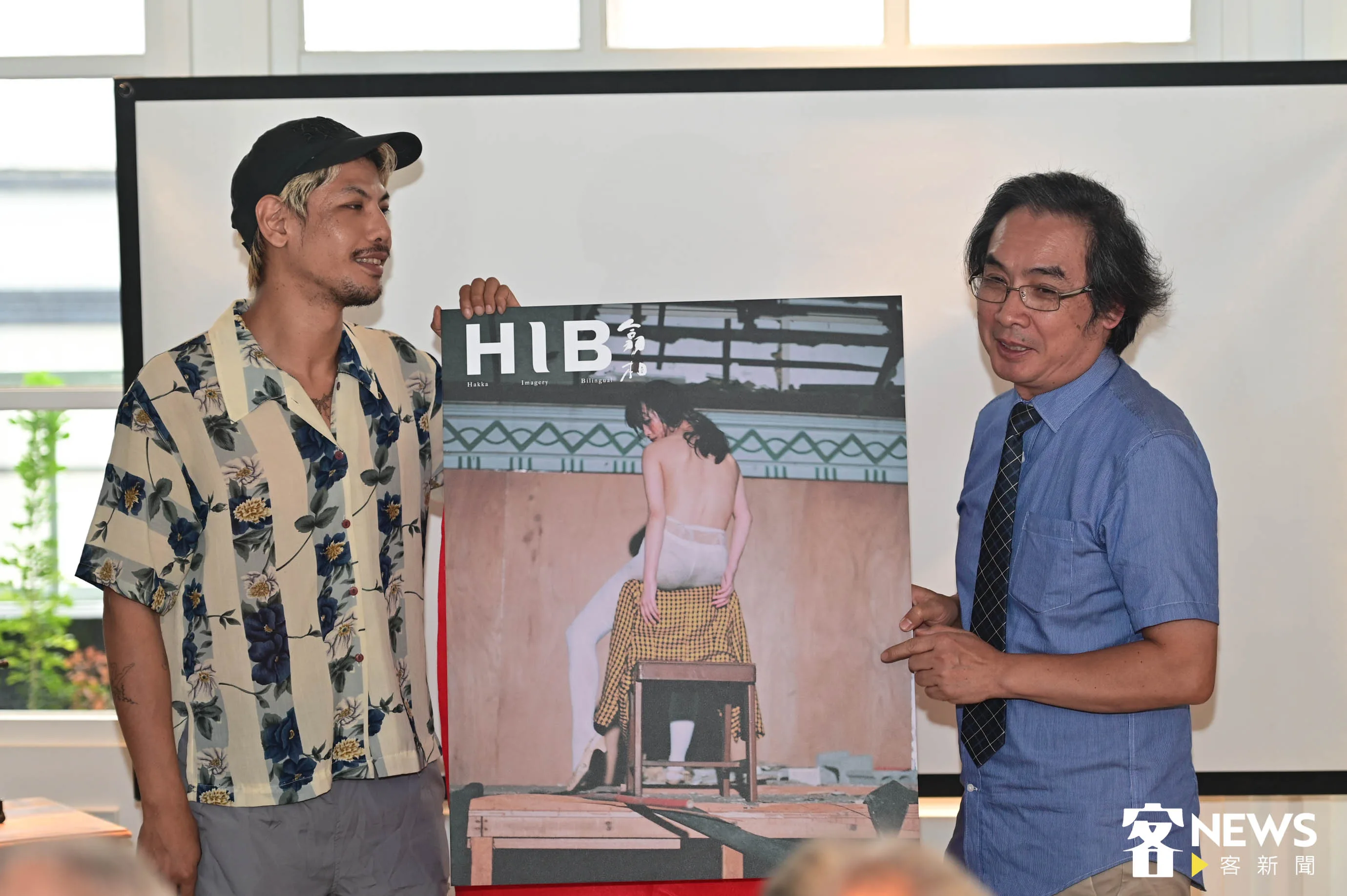 藝術家登曼波（左）與客傳會董事長陳邦畛（右）共同揭開攝全球客家攝影雜誌《HIB翕相》封面。洪俊傑攝