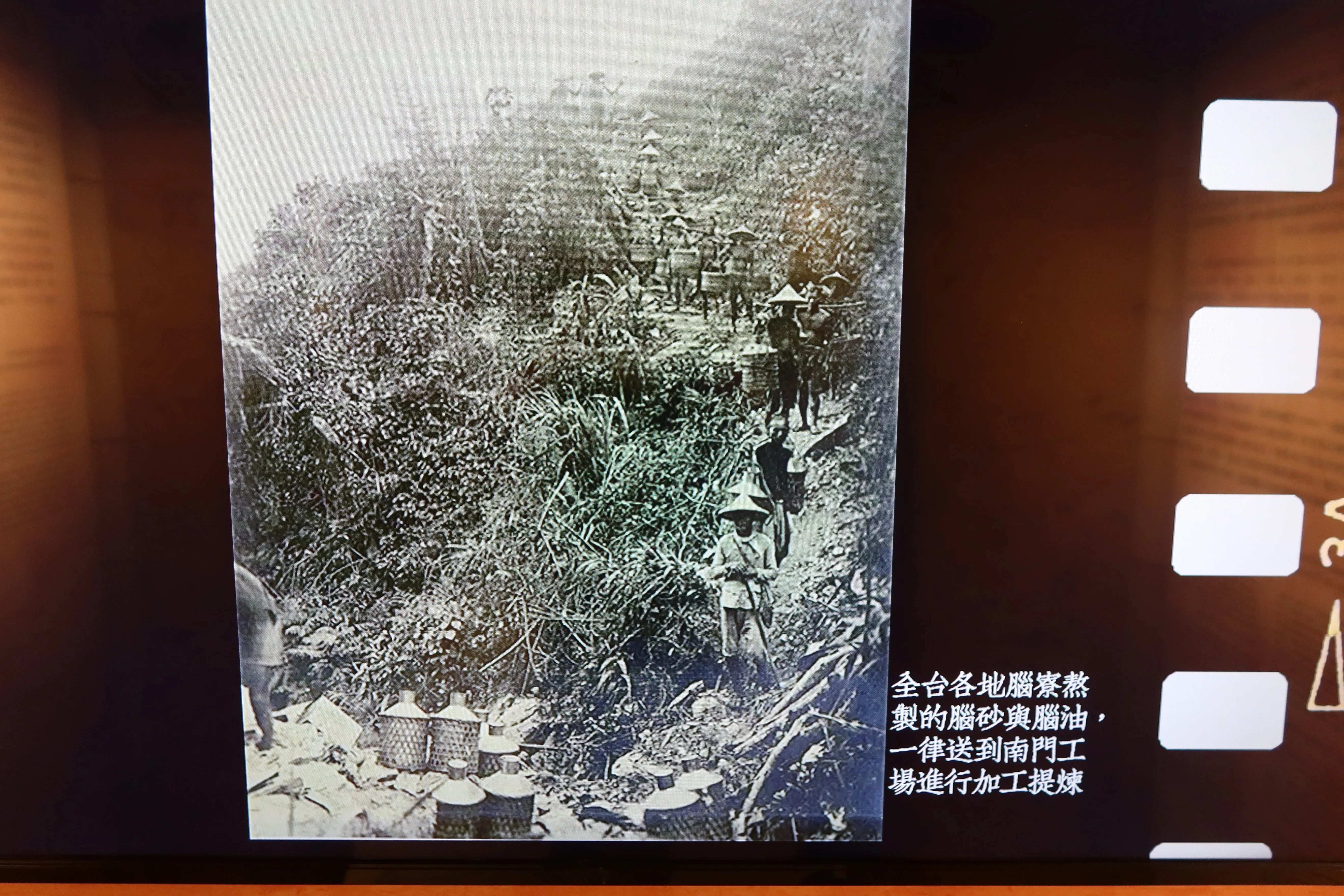 日治時期的腦丁挑著腦砂、腦油下山，集中送到南門加工廠提煉。何來美翻攝自國立台灣博物館南門分館紀錄影片