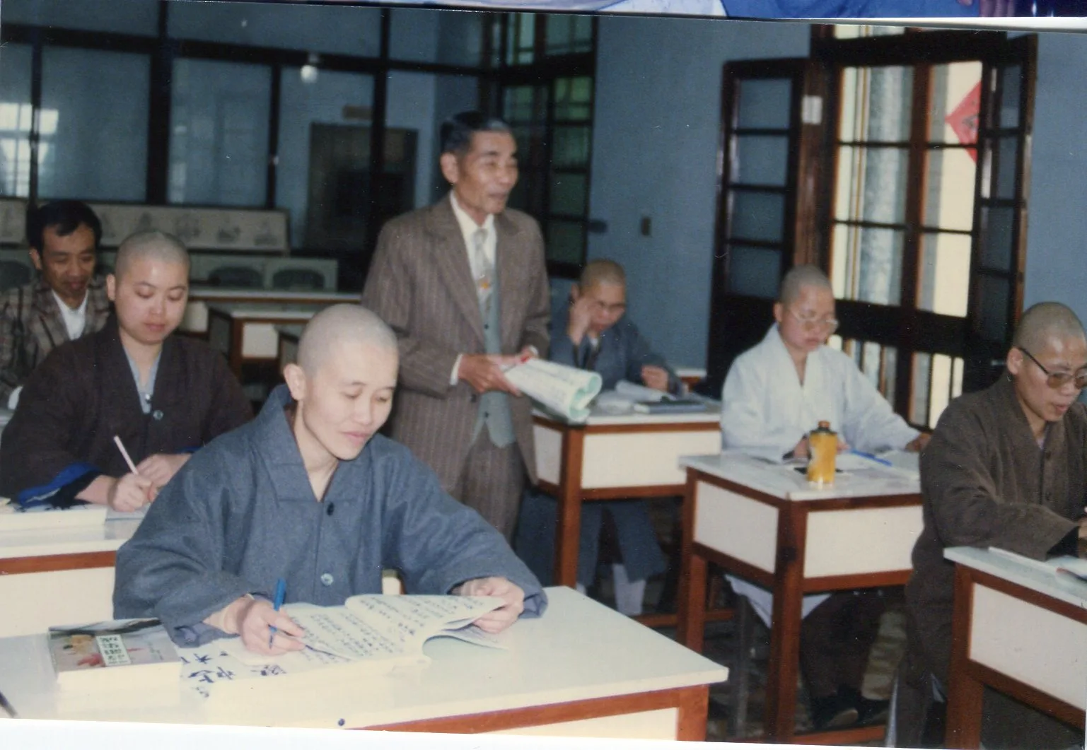 1990年賴江質到普光寺學佛，邊指導比丘尼作詩，右排前座是住持釋常端，左排後座是長子賴松峰。何來美攝