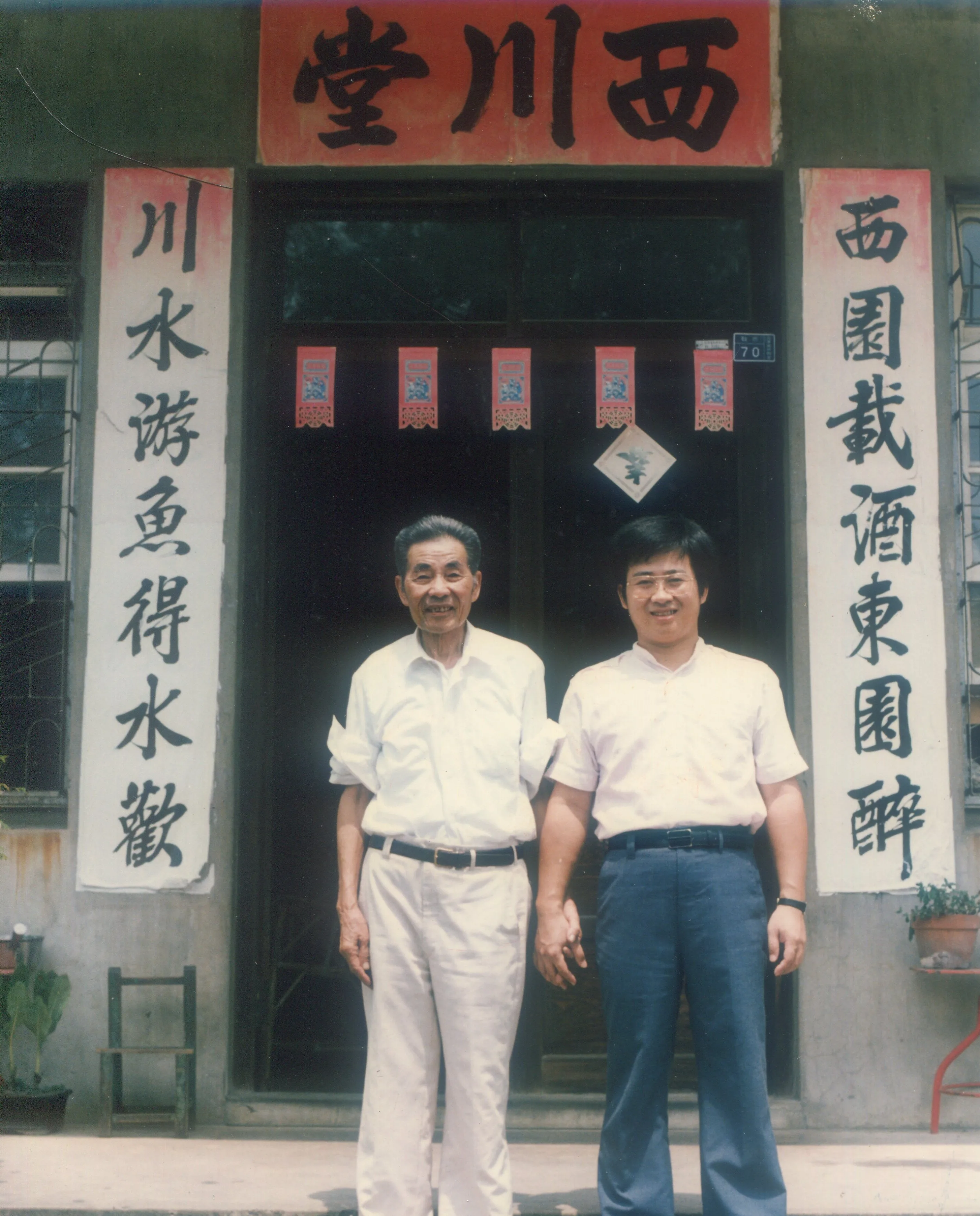 賴江質晚年在祖宅前與長孫賴煥城合影，祖孫皆是書法家，堂聯是賴江質所寫。何來美攝