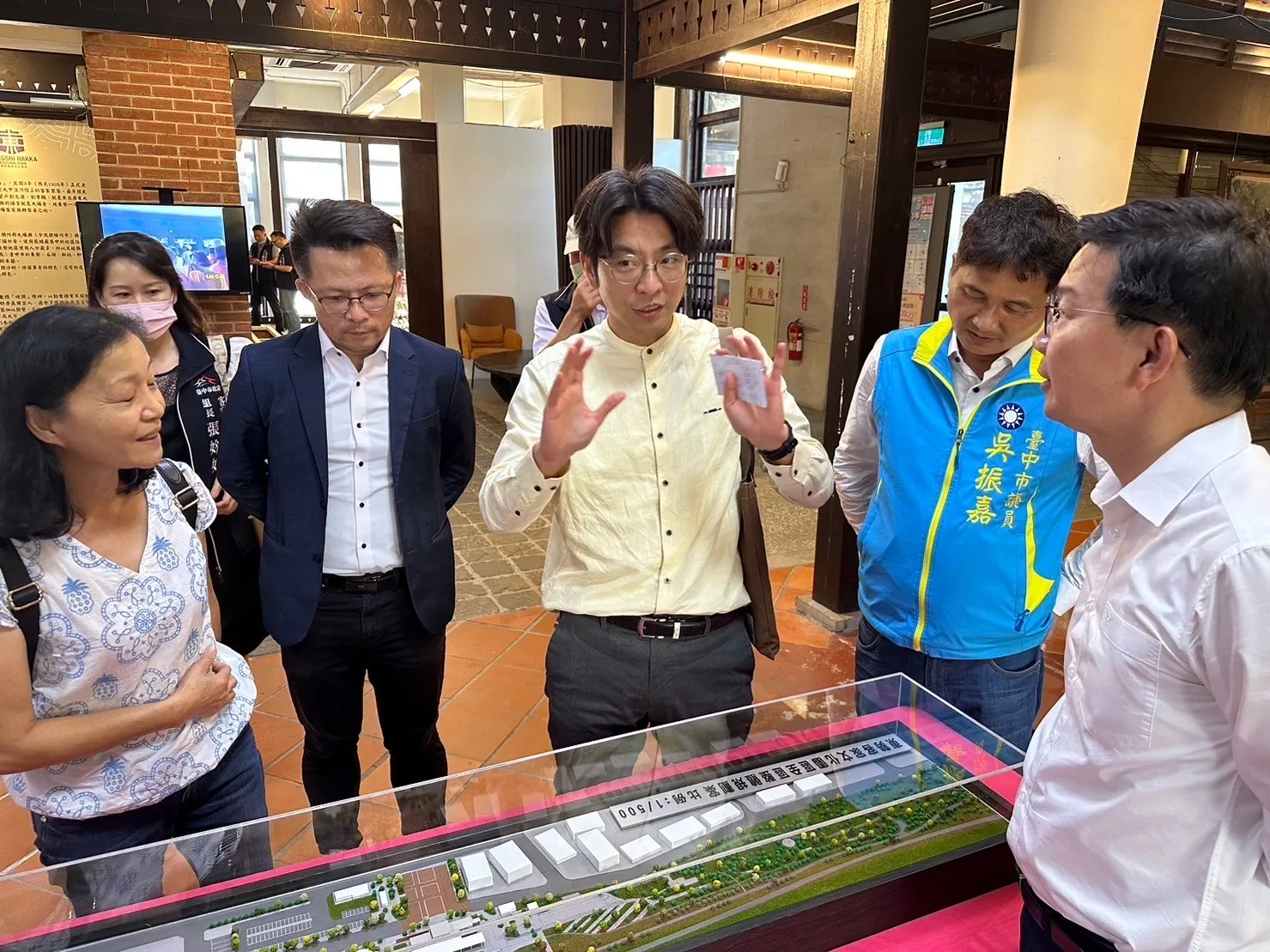 中央客委會副主委周江杰(中)與台中市客委會主委江俊龍(右一)及與惠貴賓等人觀看模型。台中市客委會提供